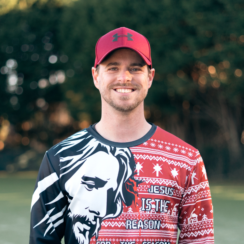 A smiling man wearing a white cap and a gray t-shirt standing next to a smiling woman with long wavy hair wearing a black jacket with white stripes on the sleeves, against a black background.