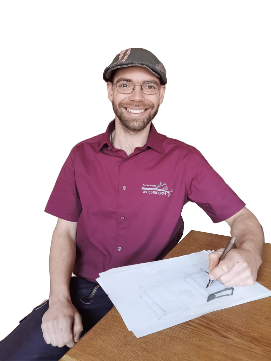 Mann mit Brille, Bart, und Bauarbeiterhelm, sitzt an einem Tisch, zeichnet technische Entwürfe auf Papier.