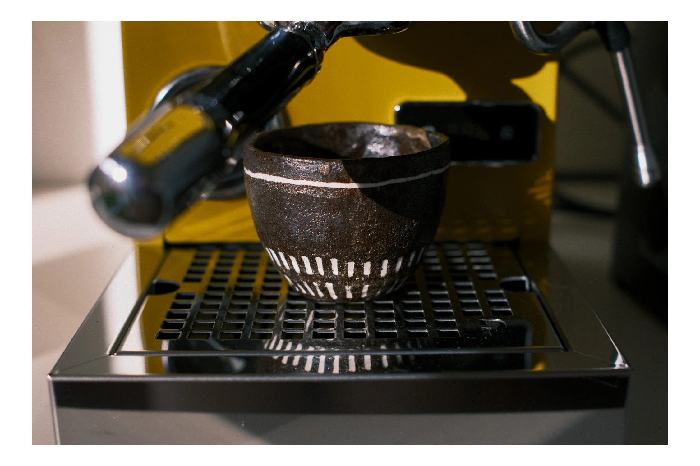 An image of a hand made coffee cup and an expresso machine.