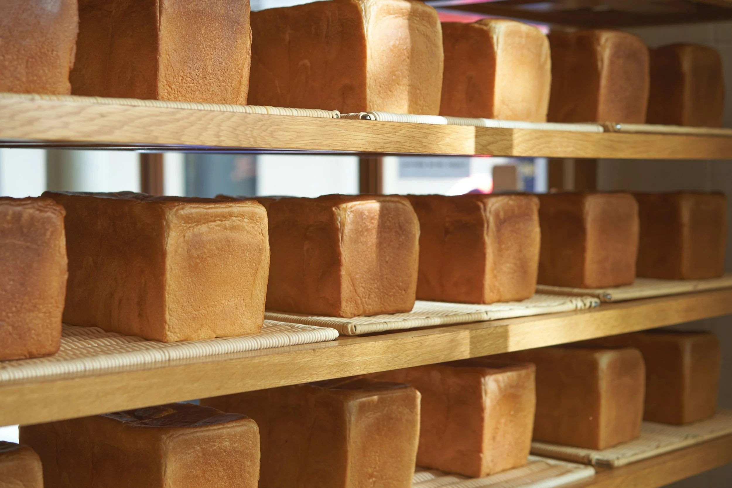 Shelves filled with freshly baked loaves of bread in a bakery.
