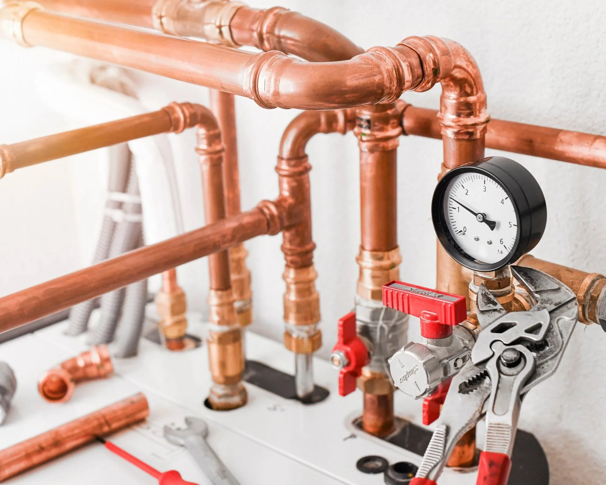 Set of copper pipes with a pressure gauge and tools.