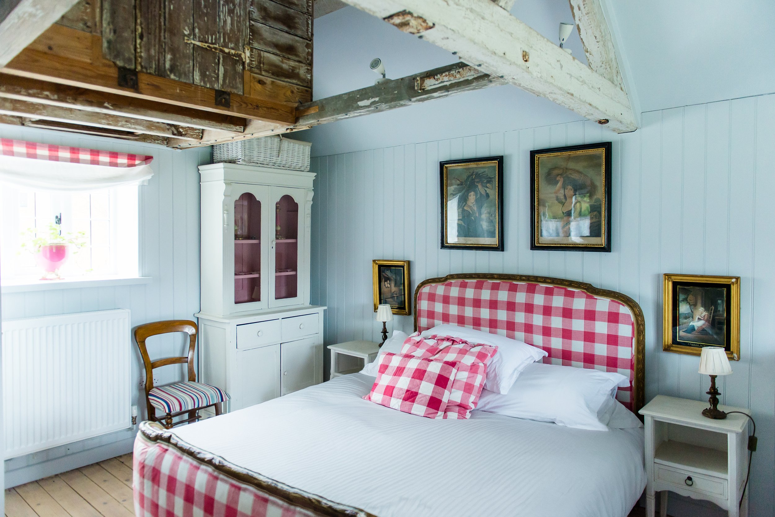 Pink and white check covered antique bed