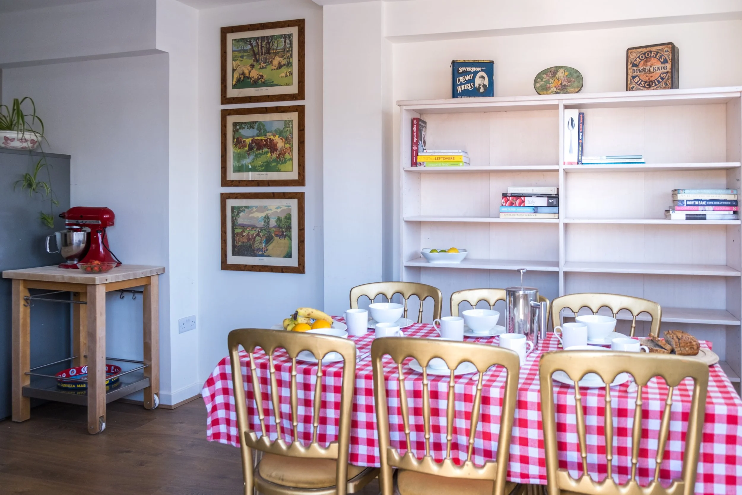 TABLE LAID WITH RED GINGHAM CLOTH AND WHITE CROCKERY