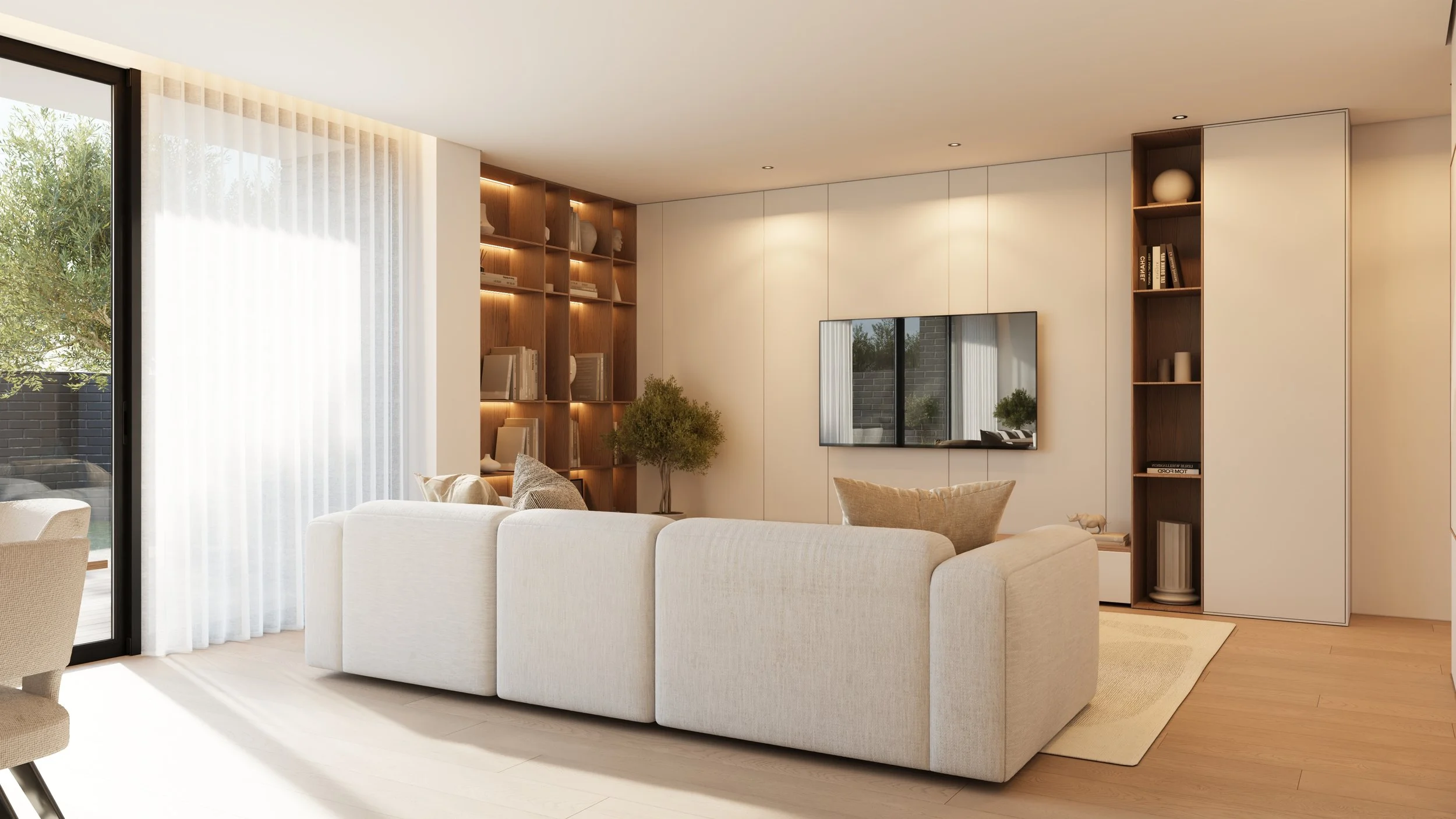 Sala de estar moderna com sofá branco, estante embutida de madeira com livros e objetos decorativos, televisão de tela plana na parede, janelas grandes com cortinas transparentes, piso de madeira clara e decoração minimalista.