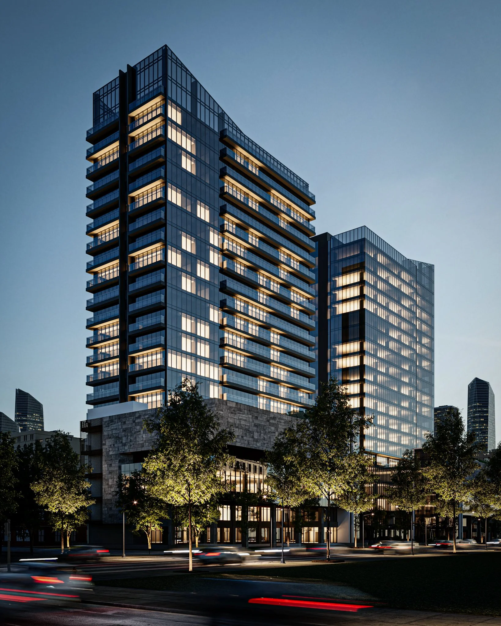 Prédio moderno de vidro refletindo luzes, árvores na frente, trânsito móvel à noite.
