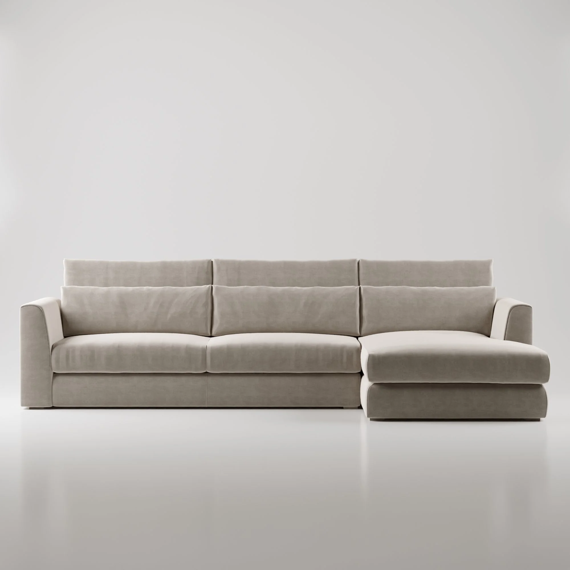 Sofá grande de veludo bege claro em um ambiente minimalista com fundo branco.