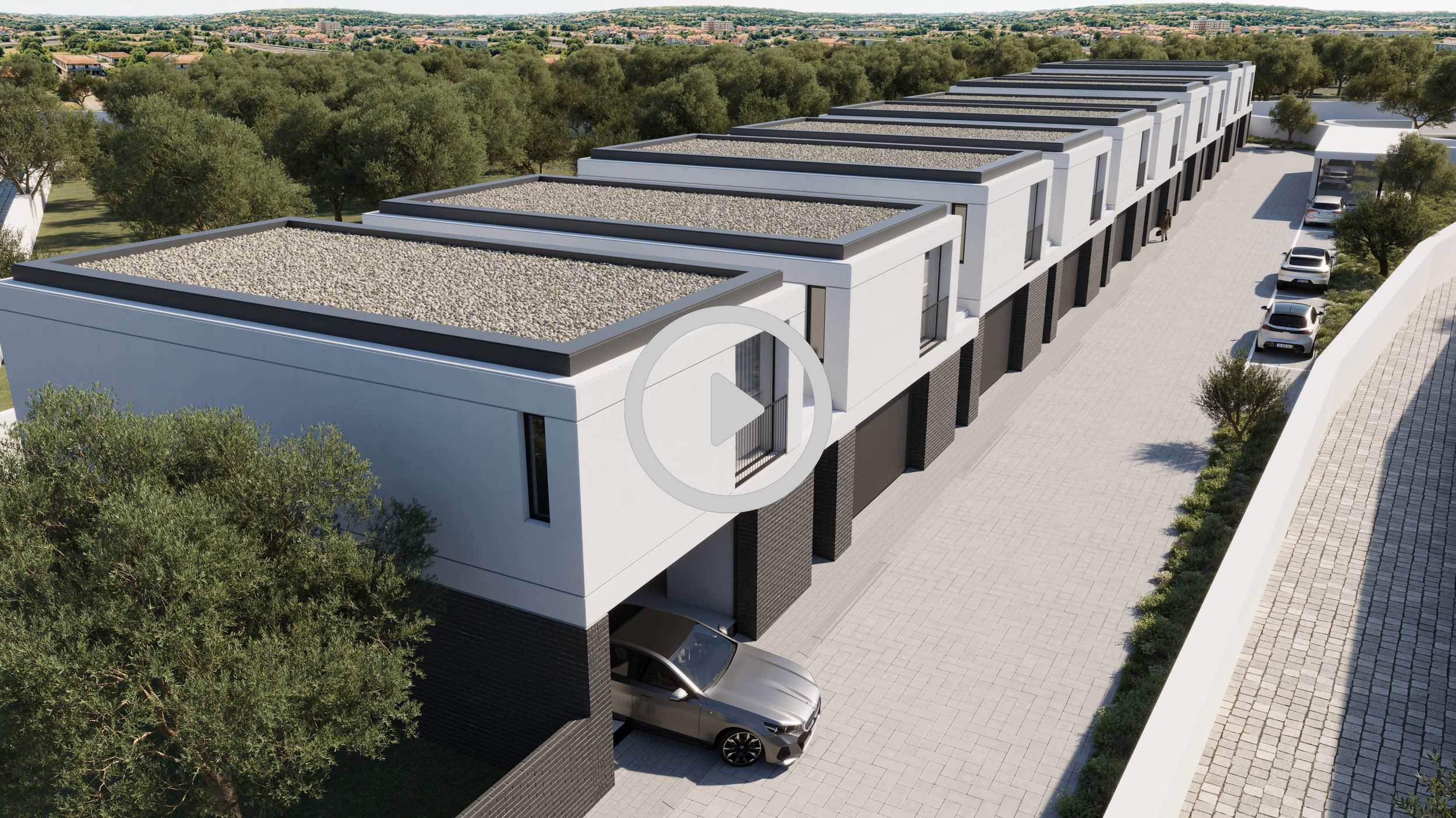 Conjunto de casas modernas em linha com telhados planos cobertos de brita, garagem com carro e área de estacionamento com várias vagas, árvores e vegetação ao redor, e uma rua pavimentada ao lado.