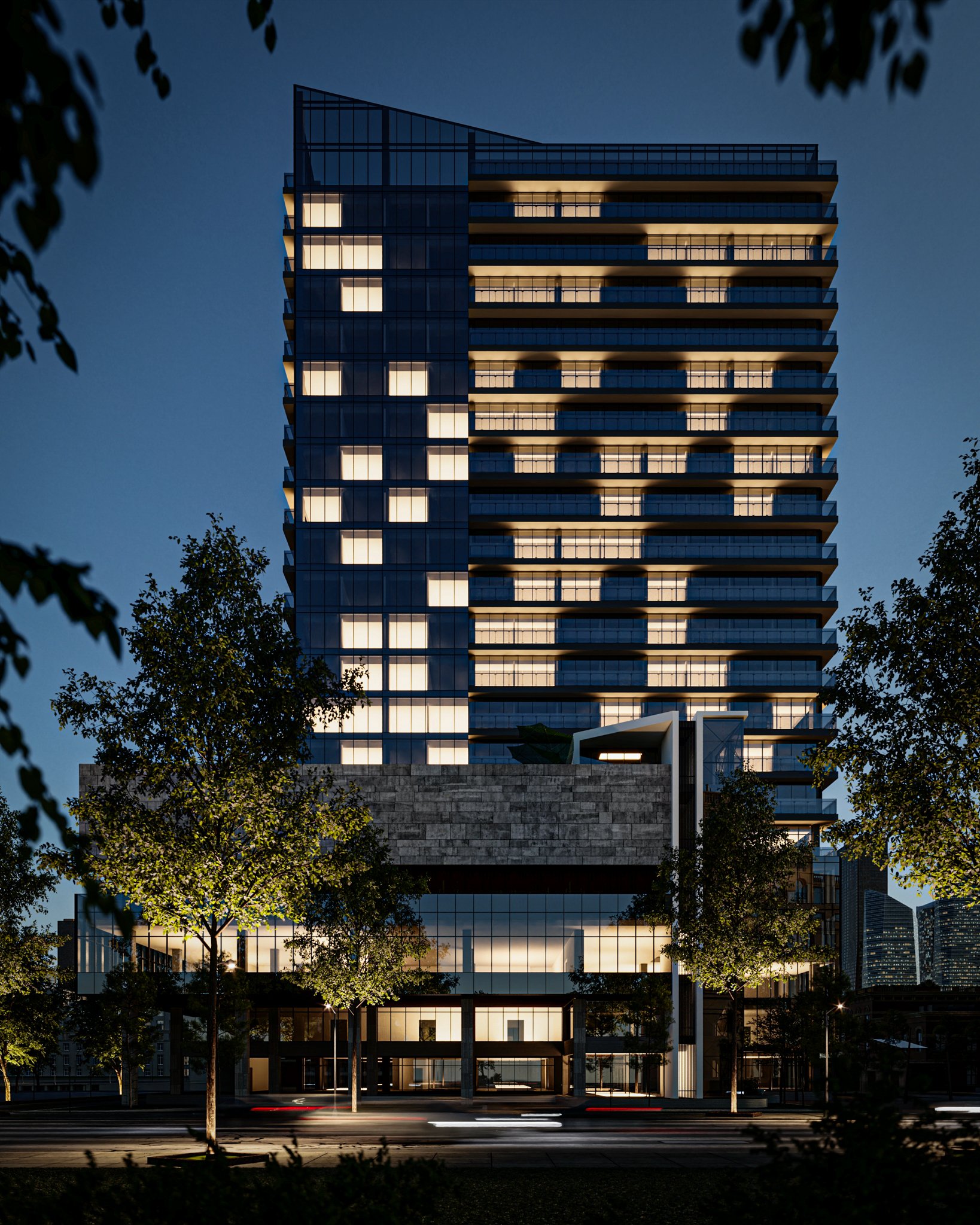 Prédio moderno de edifício alto com várias janelas envidraçadas, iluminado à noite, cercado por árvores e ruas
