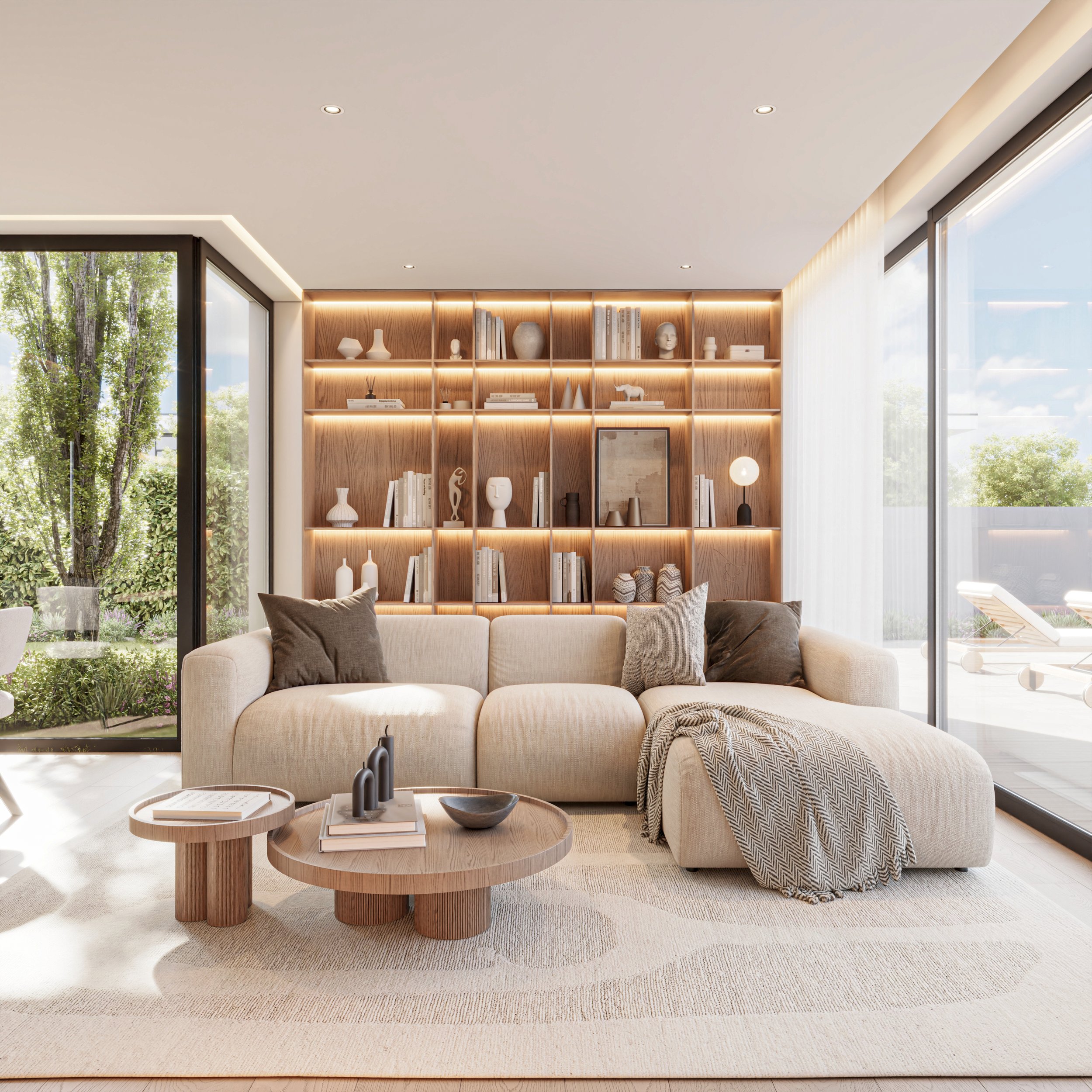 Sala de estar moderna com sofá bege, almofadas cinzas e pretas, mesa de centro de madeira com objetos decorativos, estante de madeira decorada com livros e peças brancas, grandes janelas de vidro com cortinas brancas, áreas externas com espreguiçadei