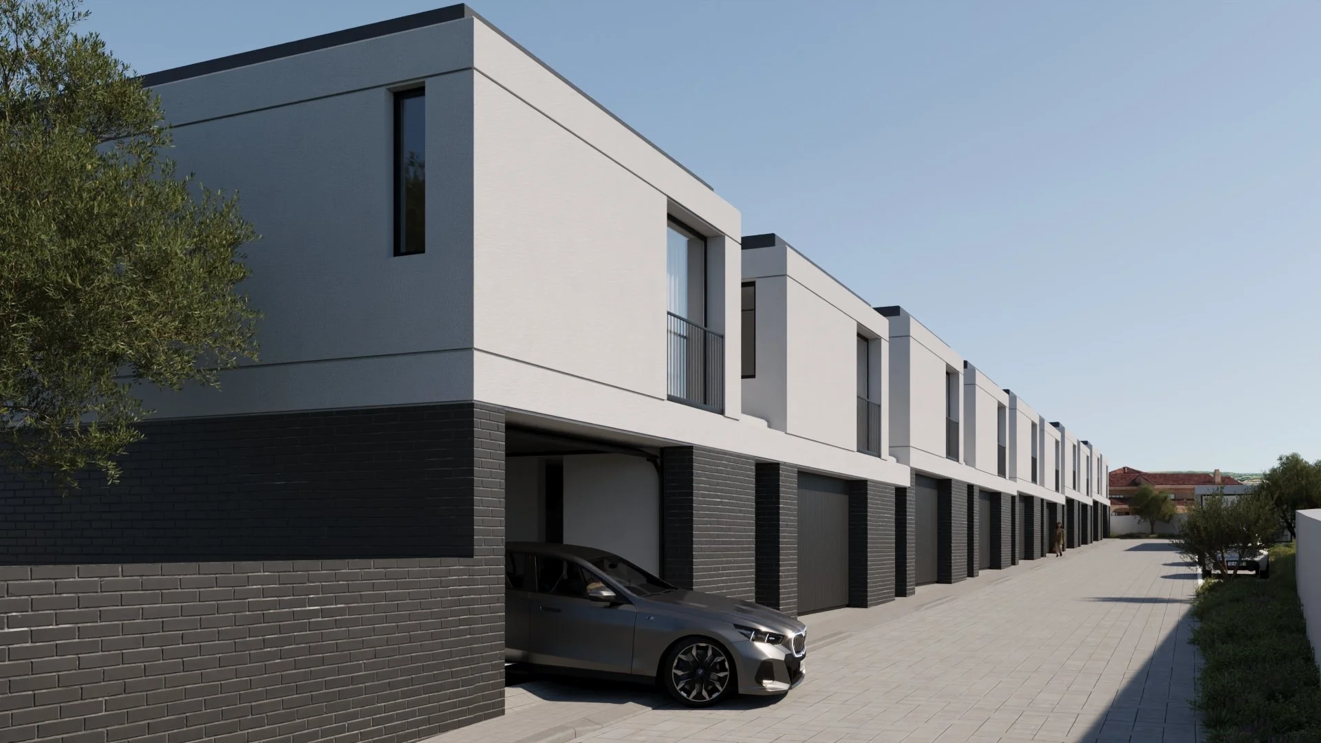 Conjunto de casas modernas com garagens na frente e carros estacionados, ruas pavimentadas e árvores ao lado, sob céu claro.