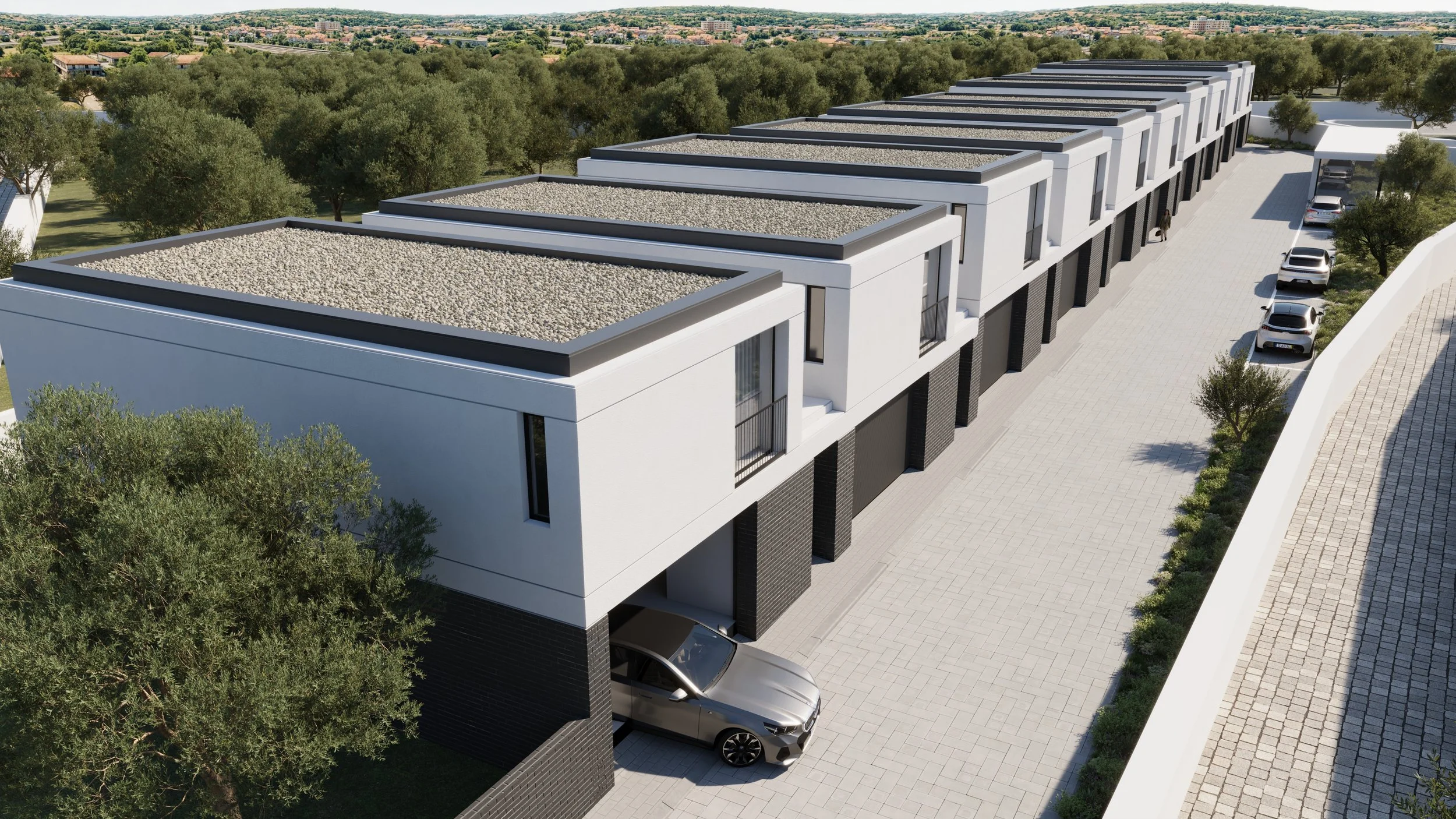 Conjunto de casas modernas de arquitetura minimalista, com telhados planos cobertos com pedras, parede branca e detalhes negros, estacionadas ao lado de uma rua pavimentada, com árvores e vegetação ao redor.