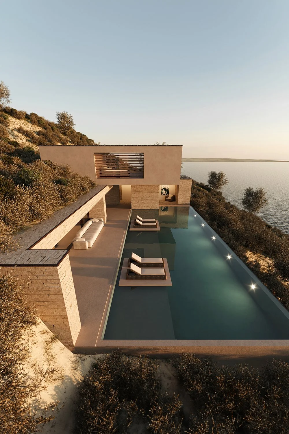 Imagem de uma casa moderna situada em um local elevado à beira de um corpo de água, com uma piscina retangular ao lado, espreguiçadeiras ao redor e vegetação ao redor.