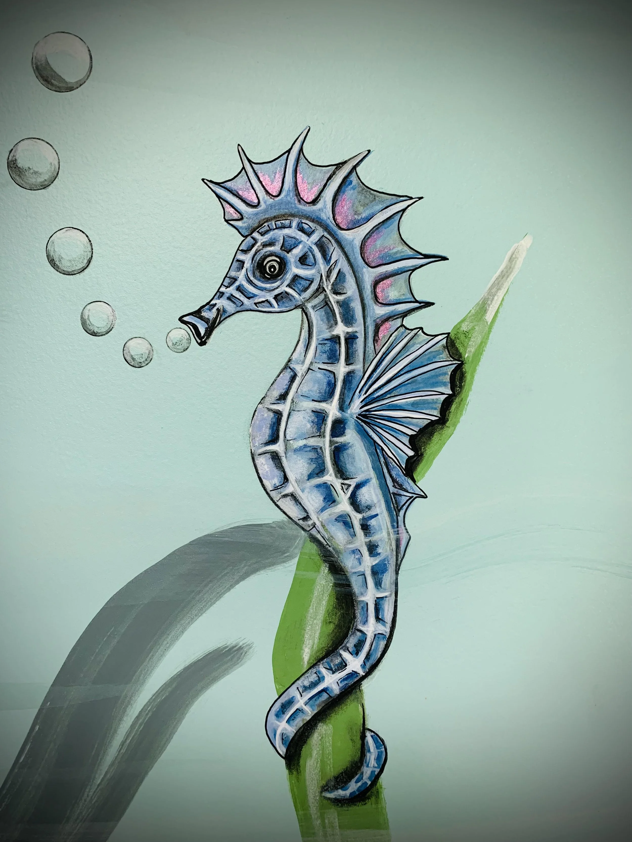 Painted artwork of a blue seahorse with pink highlights on its dorsal fin, blowing bubbles, and perched on a green plant stem against a light green background.