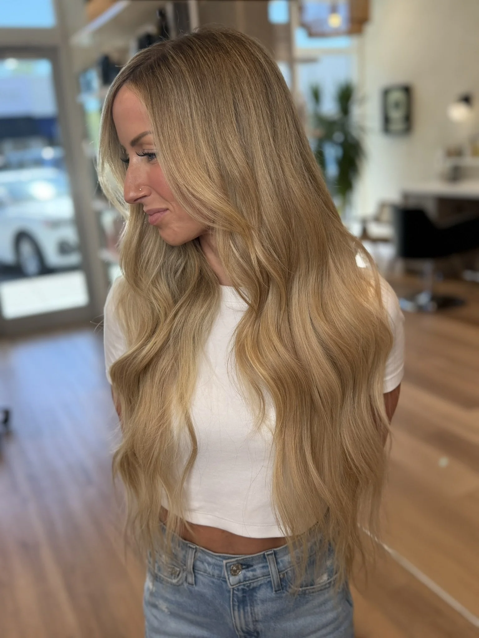 Long, natural-looking blonde Invisible Bead Extensions styled at Alexandra Siles Salon, blending with fine hair