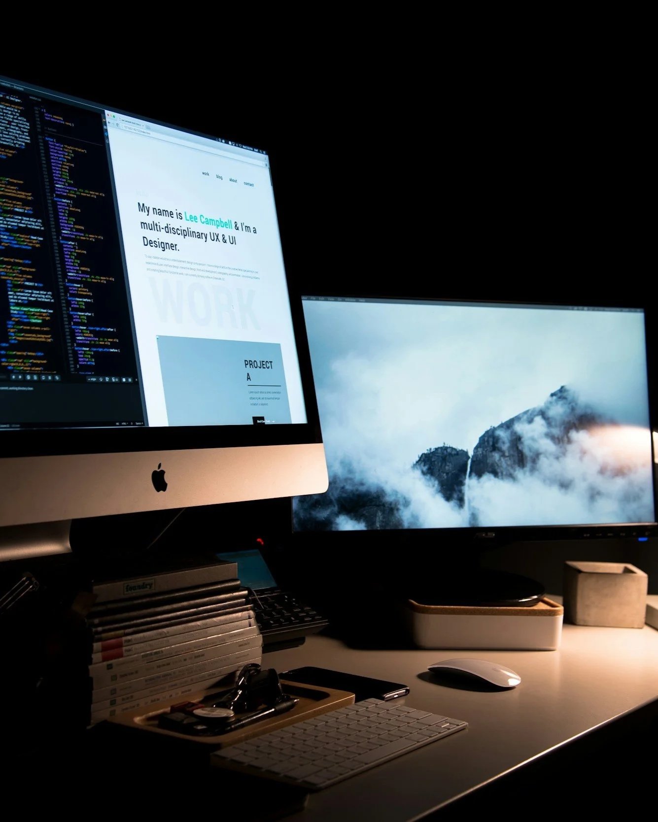 Ein Arbeitsplatz mit zwei Monitoren, einem iMac und einem zweiten Bildschirm, umgeben von Bürobedarf und technischer Ausstattung.