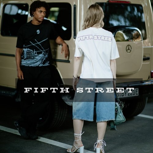 Zwei junge Menschen stehen vor einem weißen Mercedes-Benz Geländewagen, eine Person sieht von hinten und trägt ein weißes T-Shirt mit dem Schriftzug »FIFTH STREET«, die andere Person schaut auf den Wagen und trägt ein schwarzes T-Shirt mit Blauem Print.
