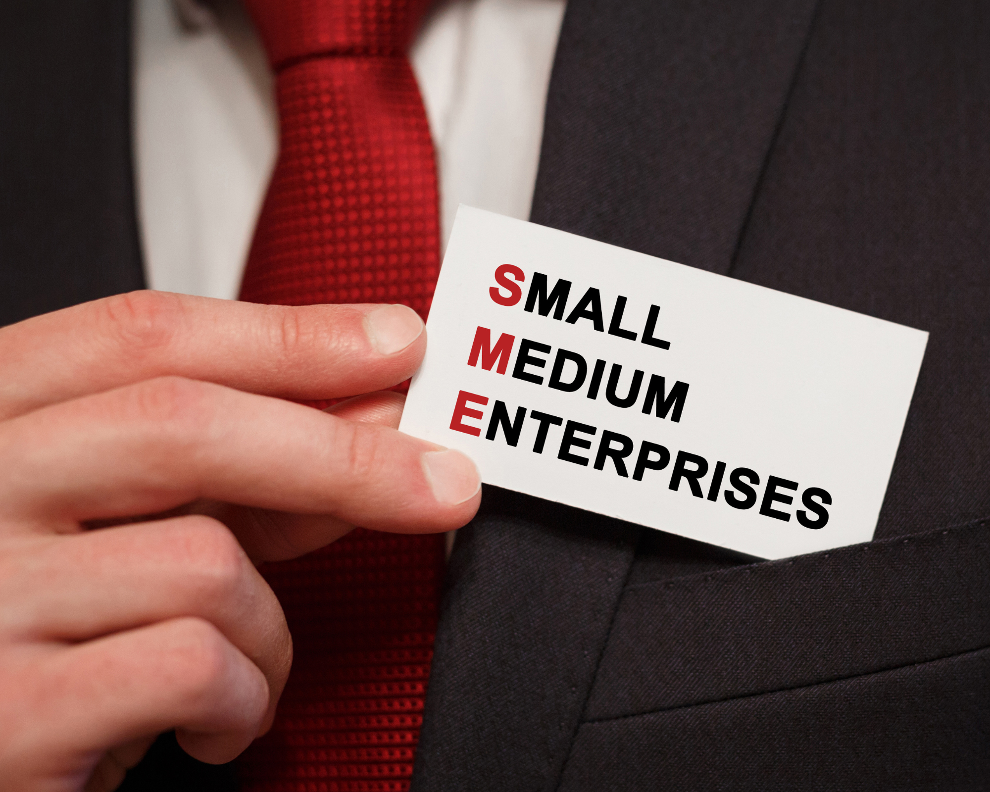 Geschäftsleute in Anzügen, mit einem Namensschild, auf dem die Größen Small, Medium und Enterprise in Großbuchstaben und Farbe hervorgehoben sind.