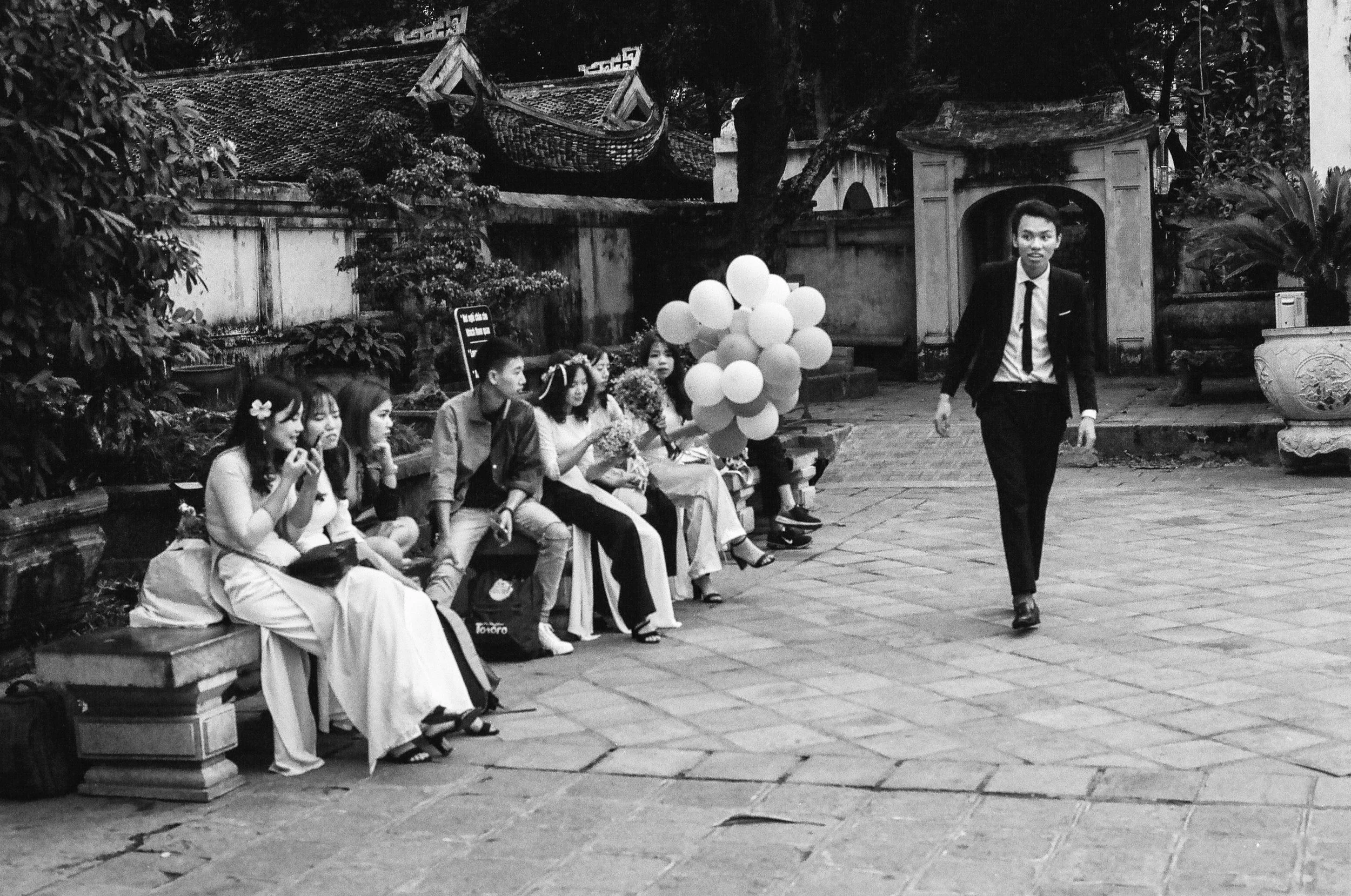 Un groupe de jeunes vietnamiens en costumes, célébrant un mariage dans un temple de Hanoï
