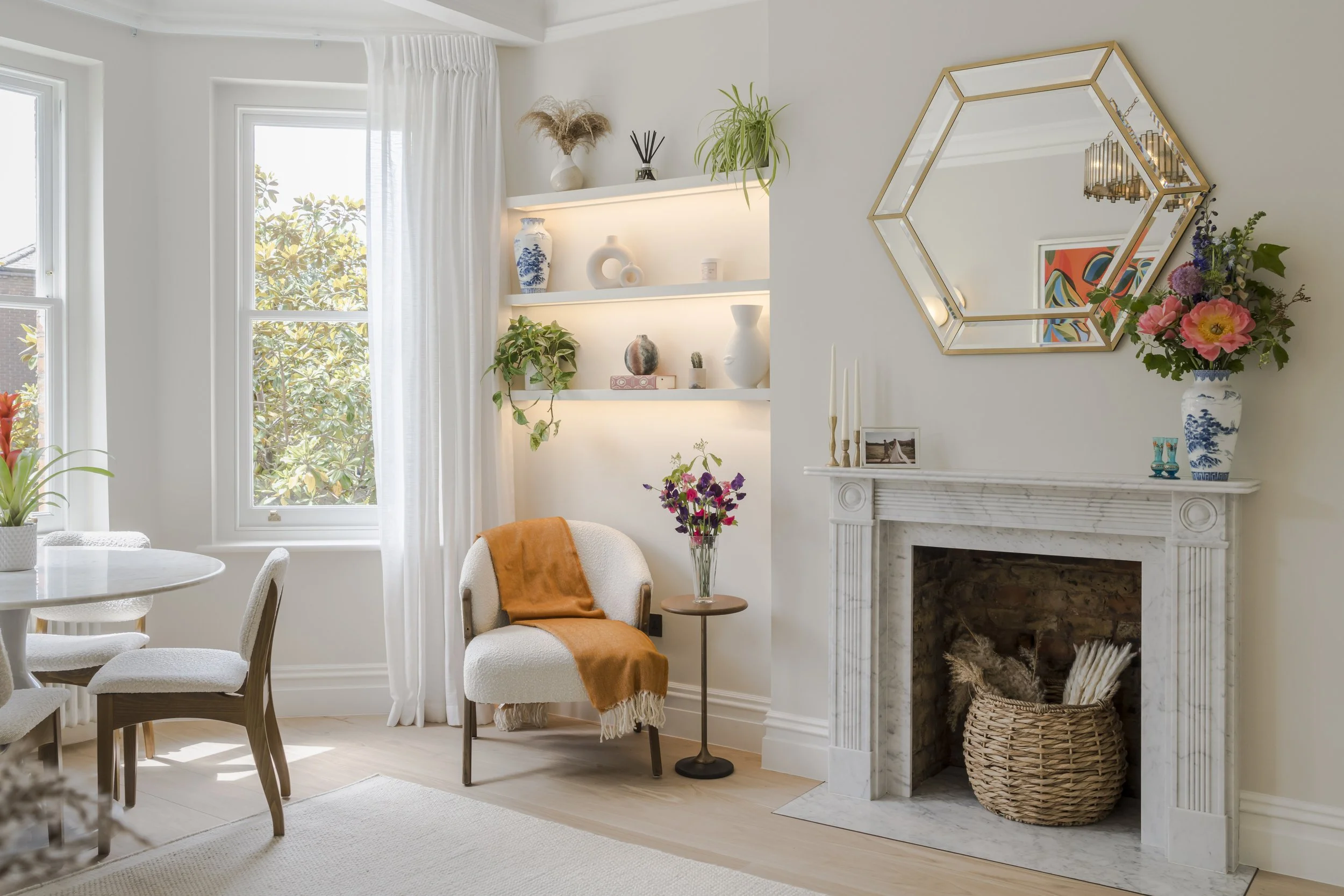 Entrance to a red brick residential building with a black door, white trim, and a black sign that reads 'Ashburnham Mansions Nos. 36-55'. The entrance is accessed by a black and white checkered tiled walkway lined with black metal railings and small green bushes on both sides.