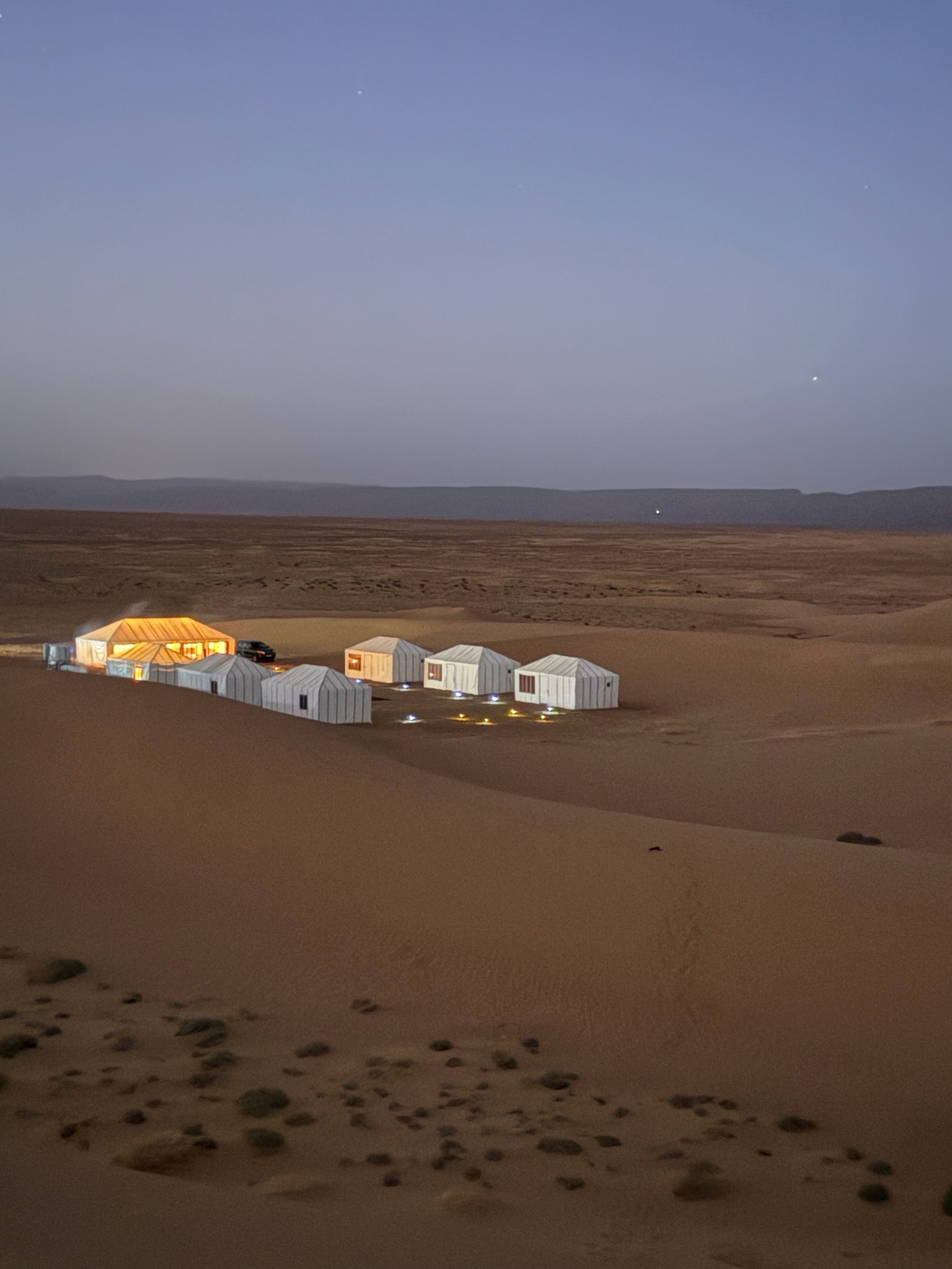 Nestled in the dunes of Erg Lihoudi, Arawan Luxury Camp sits quietly under the sky as night falls.