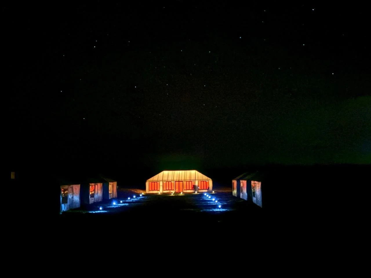 Arawan Luxury Desert Camp illuminated at night under blankets of stars.