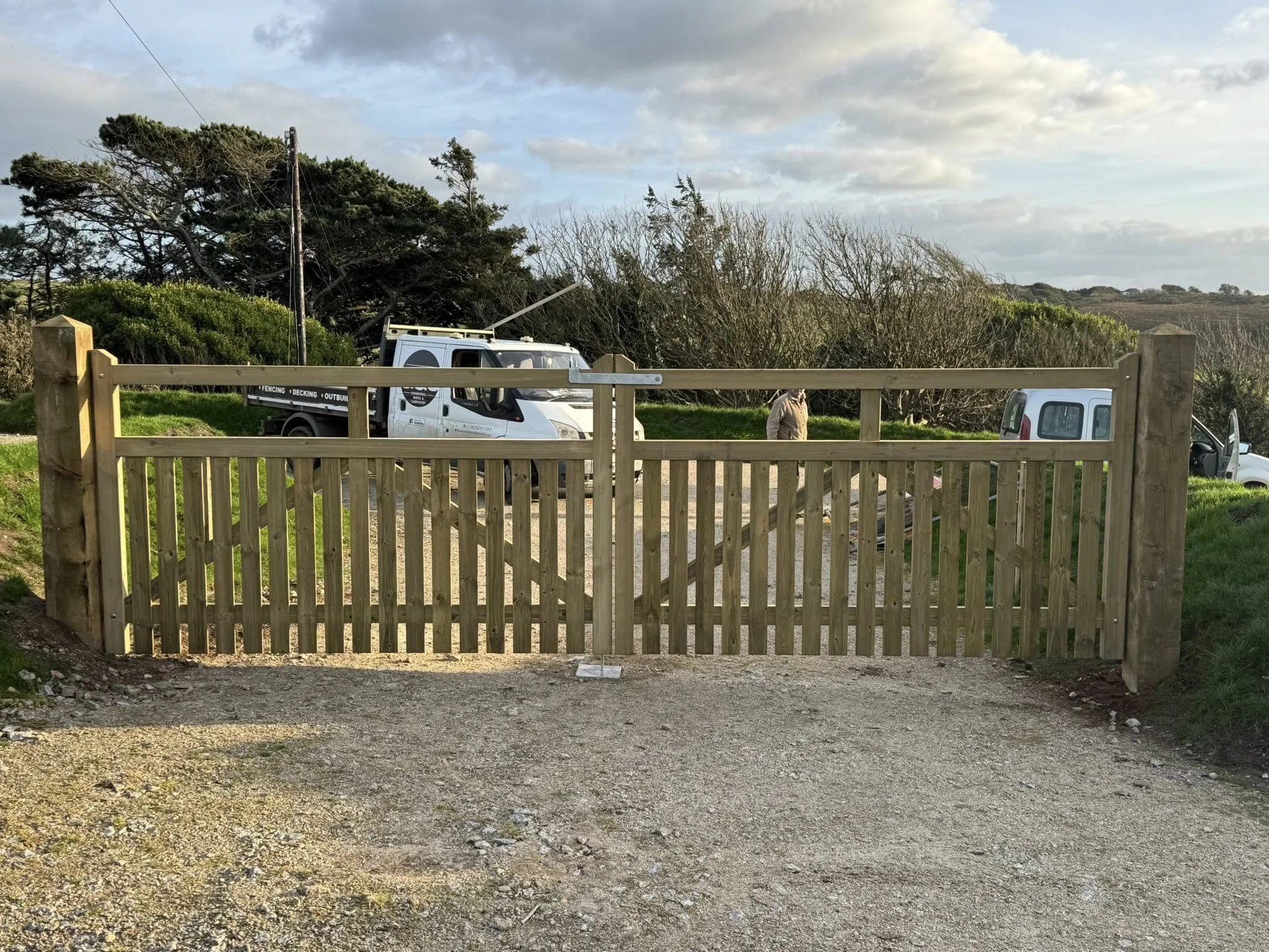 Modern double driveway timber gate with vertical gapped panels for privacy and airflow, built in Cornwall.