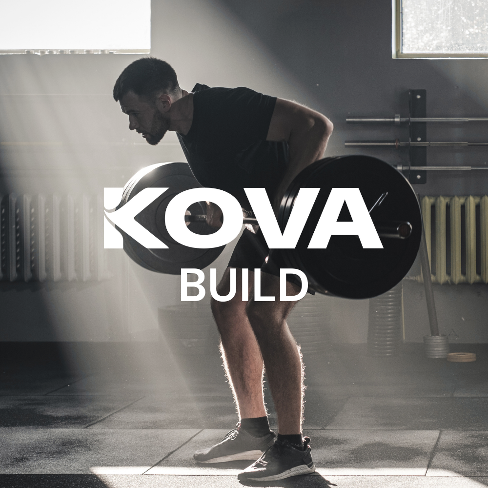 Man lifting a barbell in a gym with sunlight streaming through a window with the words 'KOVA BUILD' overlaid.