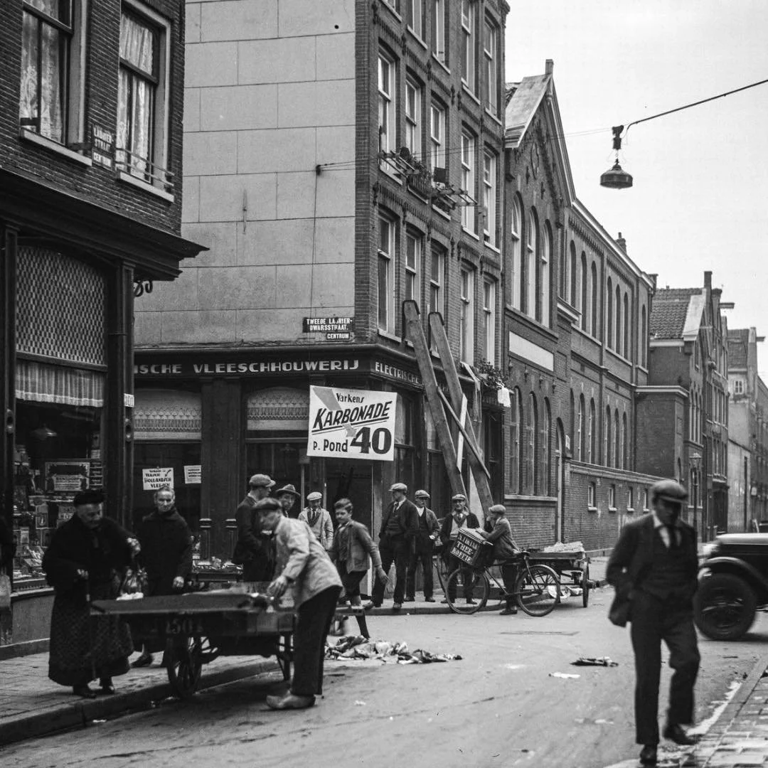 1932 &amp; Now: in this photo you see Laurierstraat on the corner of Tweede Laurierdwarsstraat. The building at Laurierstraat 103-105 used to be home to the butcher shop of J. Vrees.
A little further down the road, you see a larger complex that is si