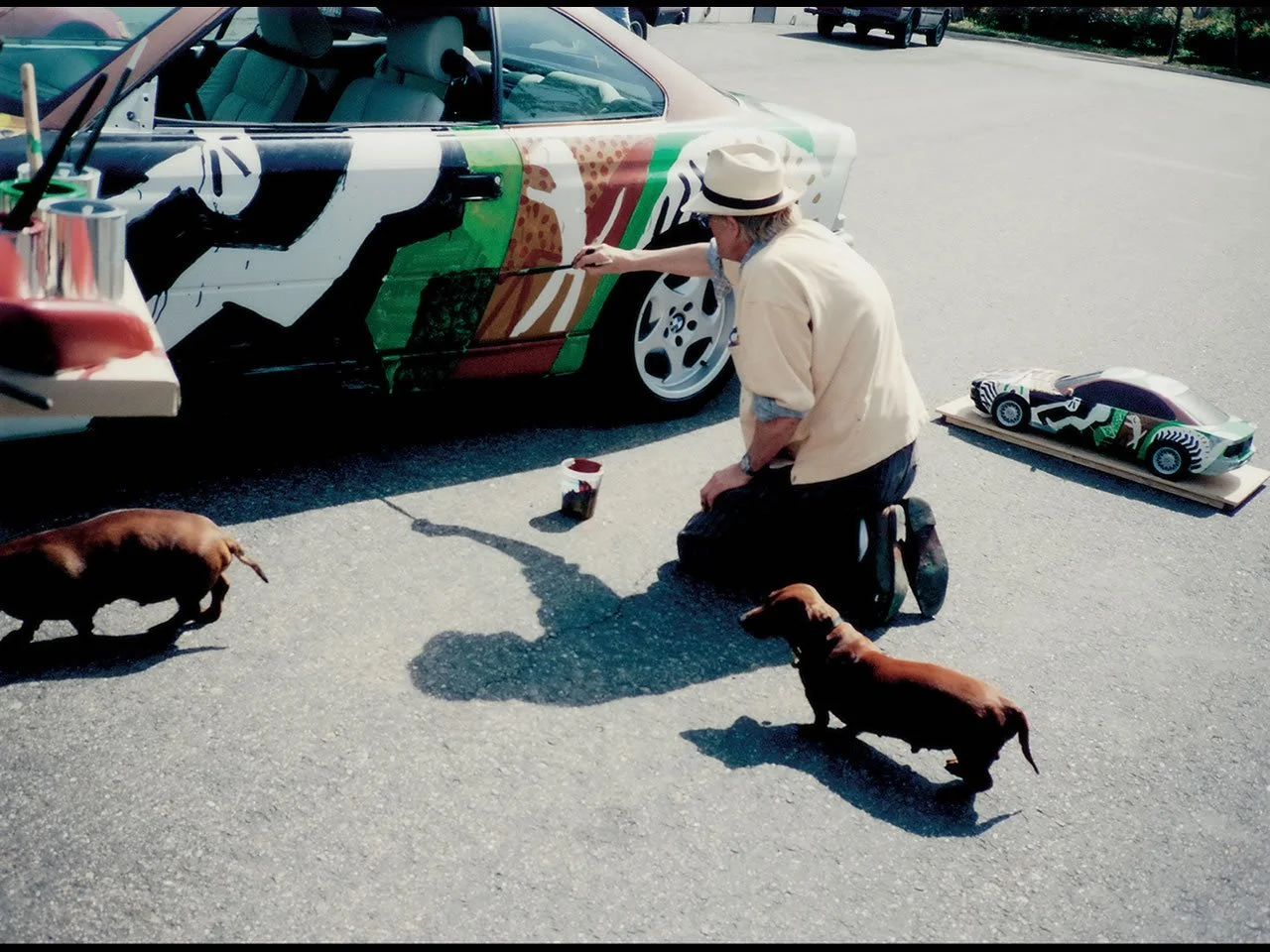 David Hockney and his dogs painting a BMW 850CSi.