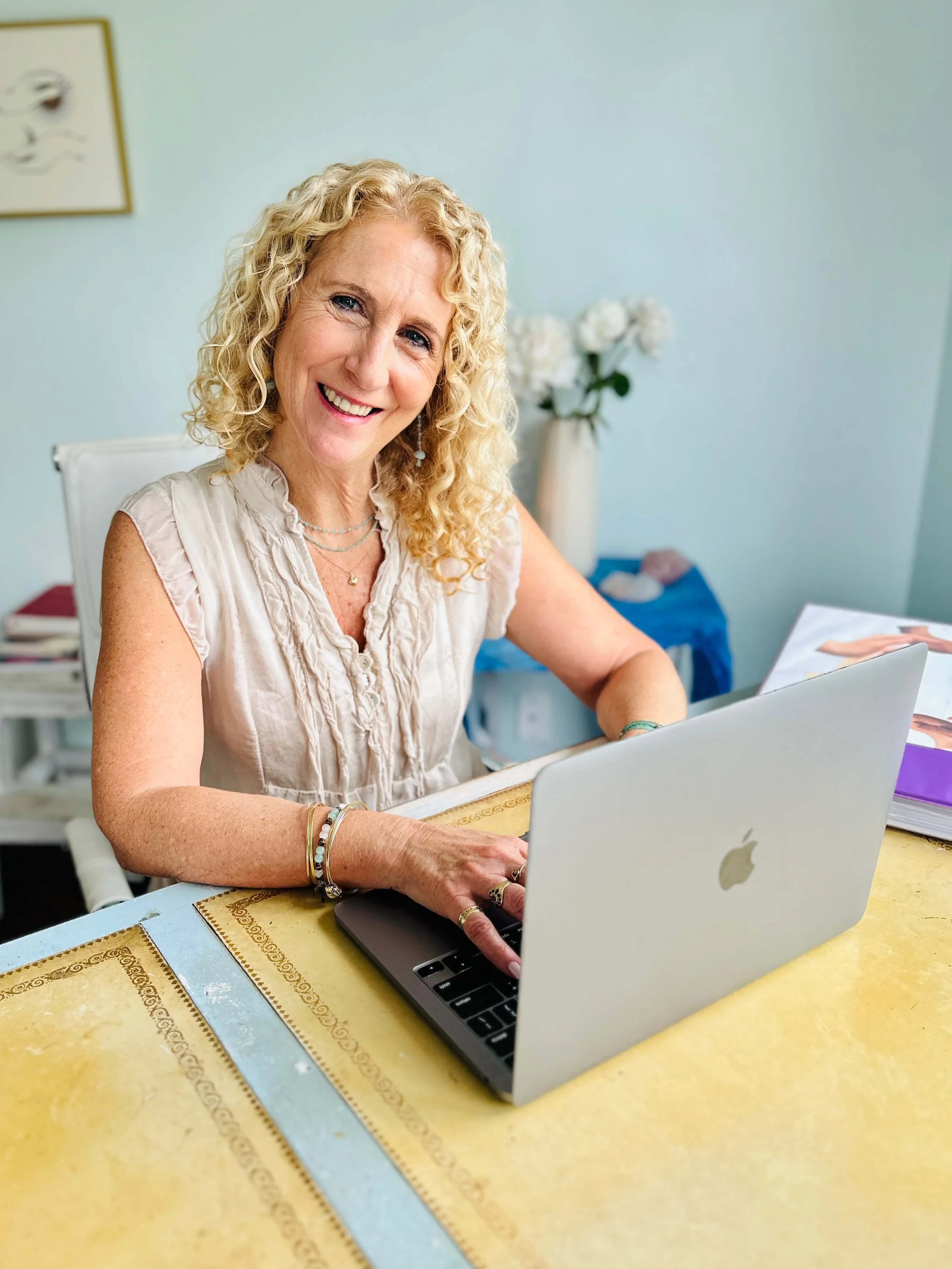 Jozi Radus working with a client at her home office and smiling.