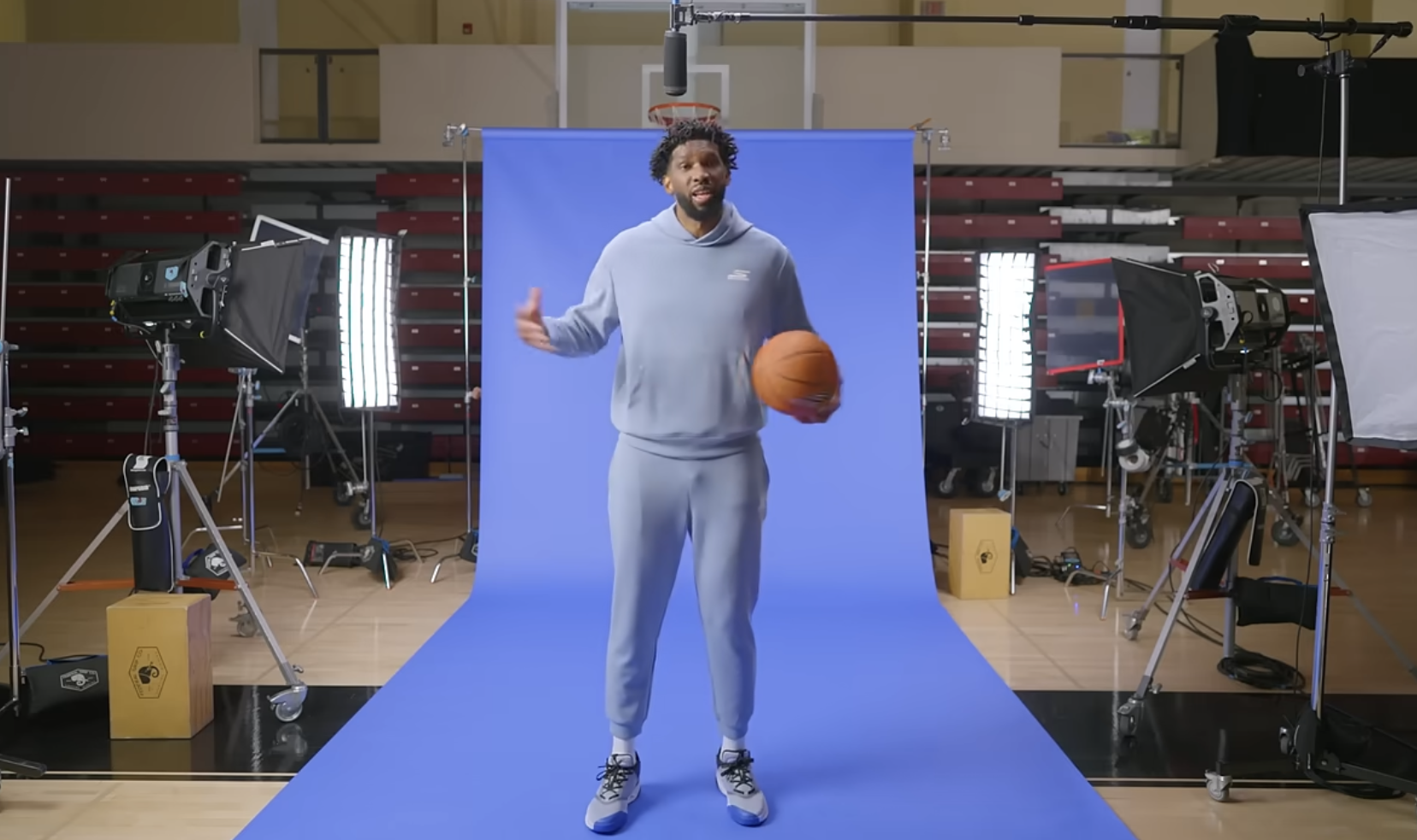 Joel Embiid stands holding a basketball, as seen in a commercial styled by Lindsay Foret, creatively invigorating the look and feel of film and tv commercial production in the Greater Philadelphia market.