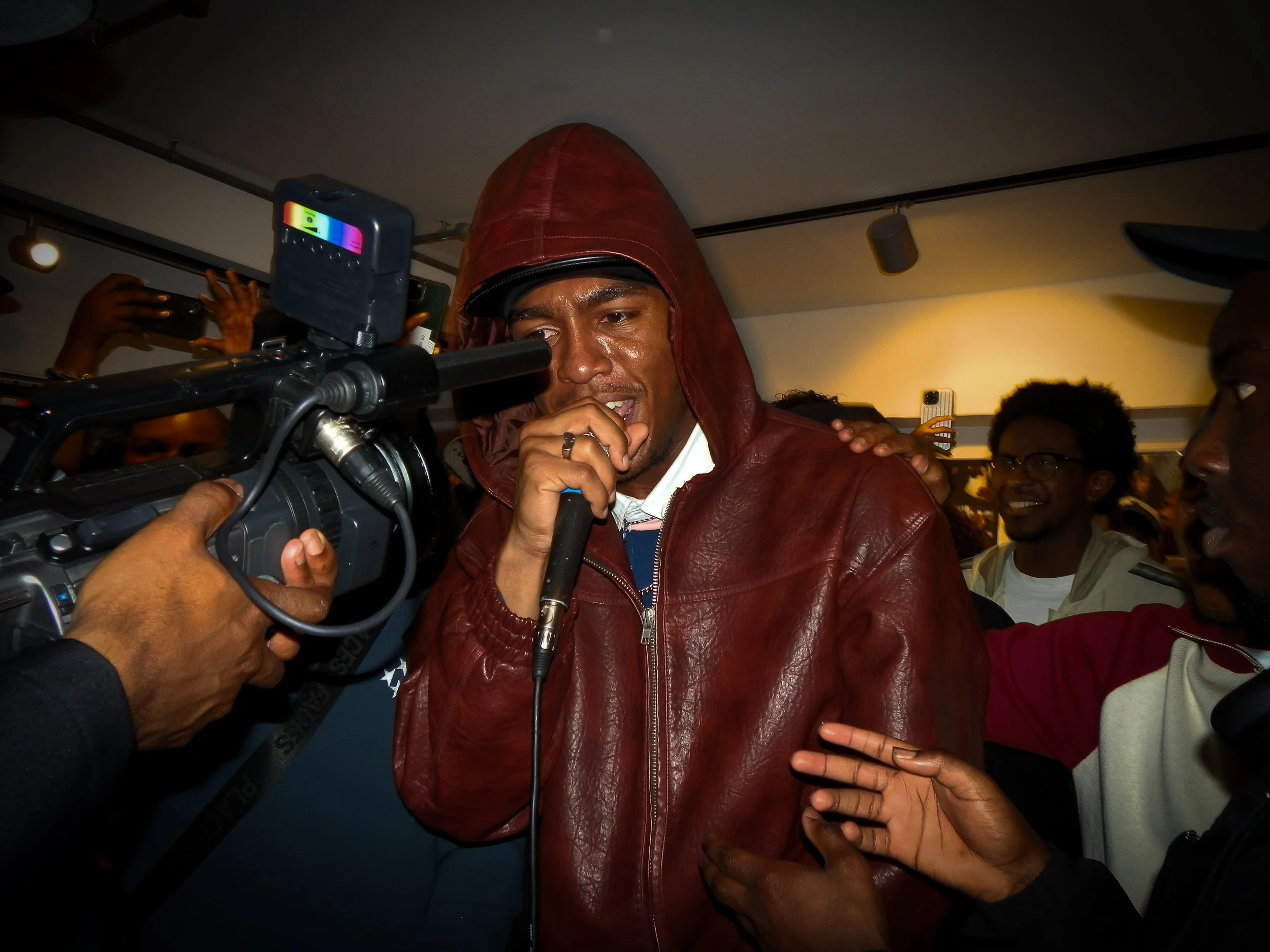 mc performing into a mic and cam corder at victory lap pop up cypher for simon Wheatley's don't call me urban book launch