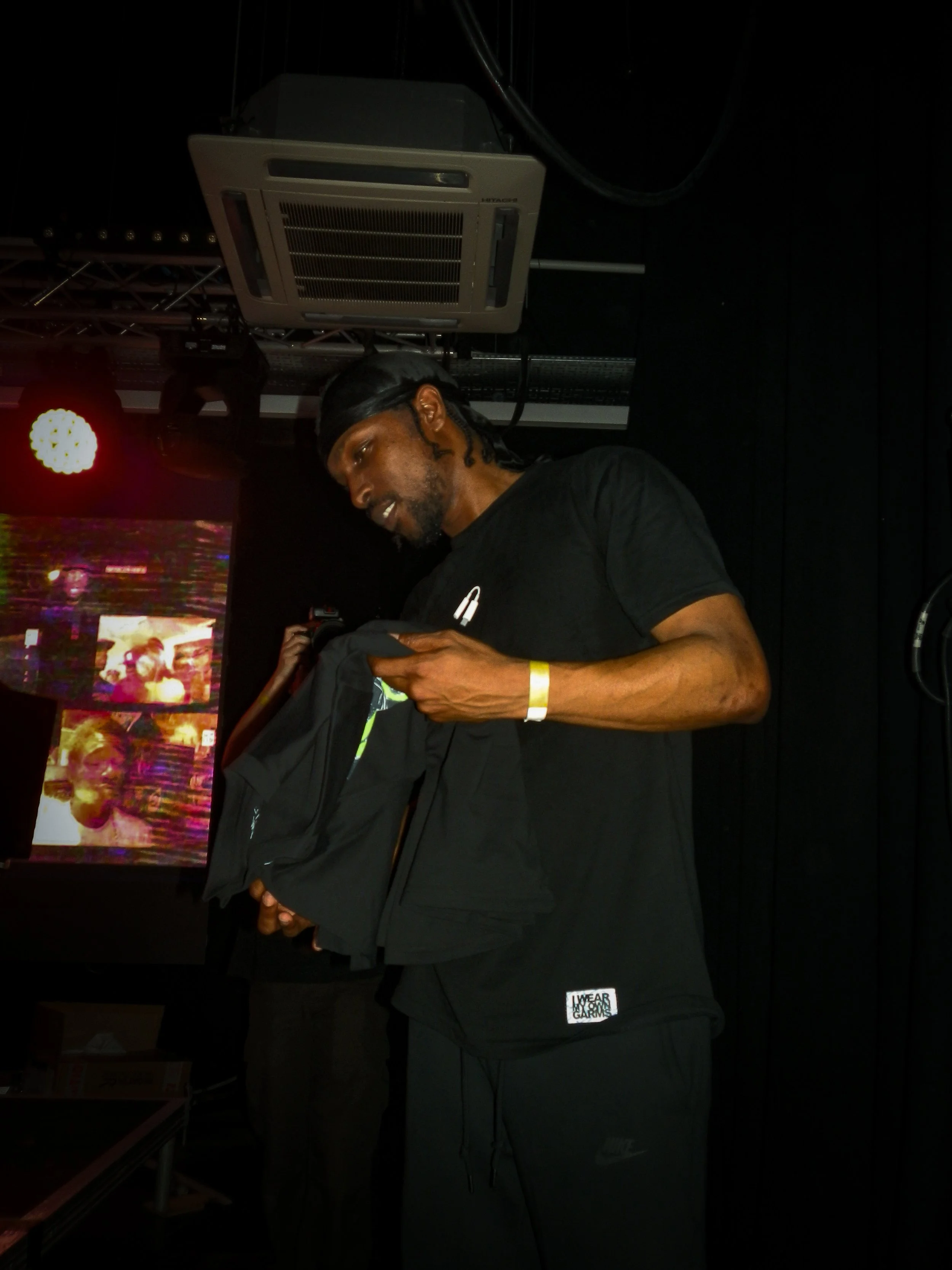 grime musician jme holding a t shirt in front of crowd barrier