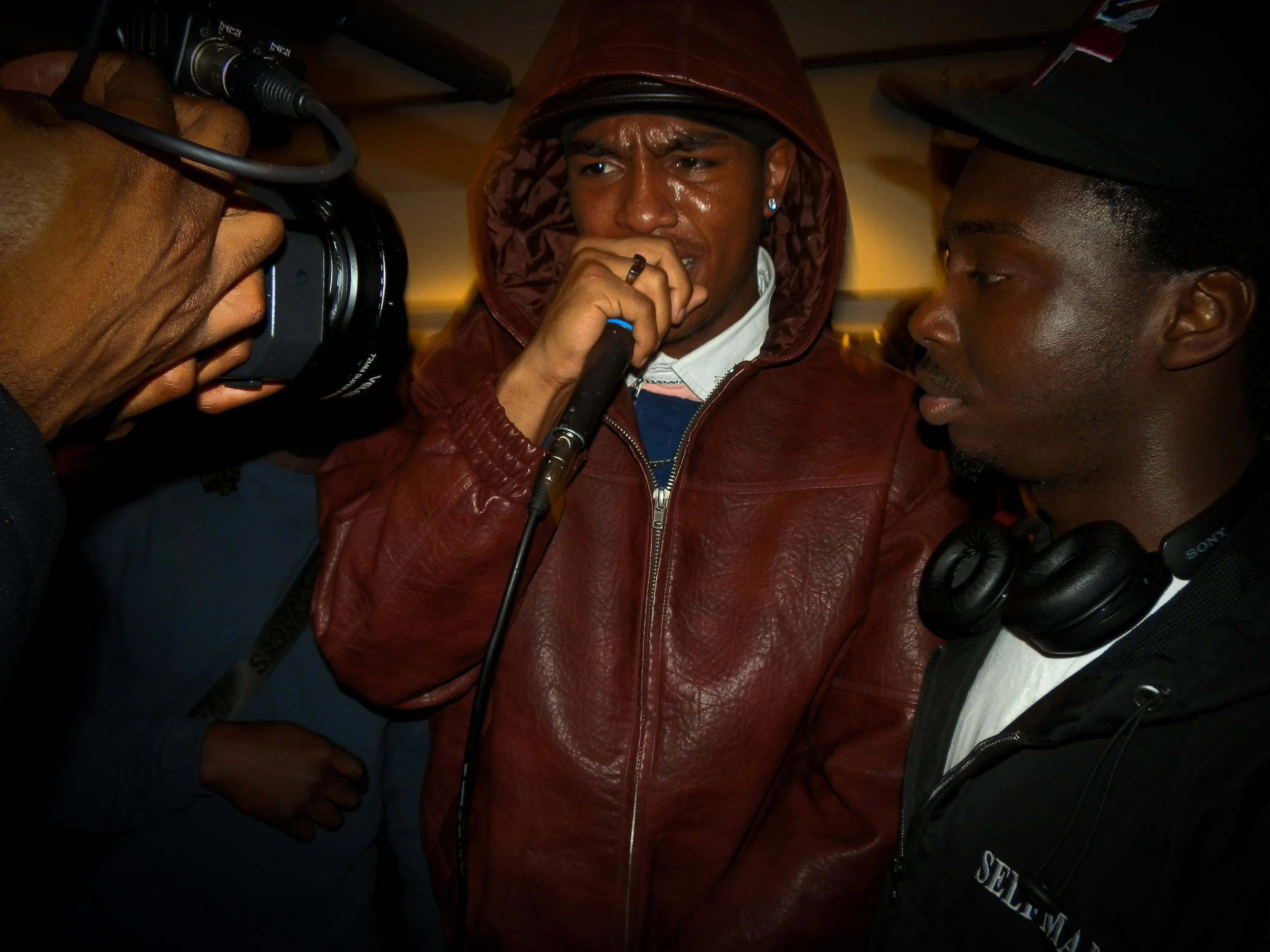 young mc performing into mic and camera at the victory lap collaboration cypher at the simon wheatley don't call me urban book launch and signing