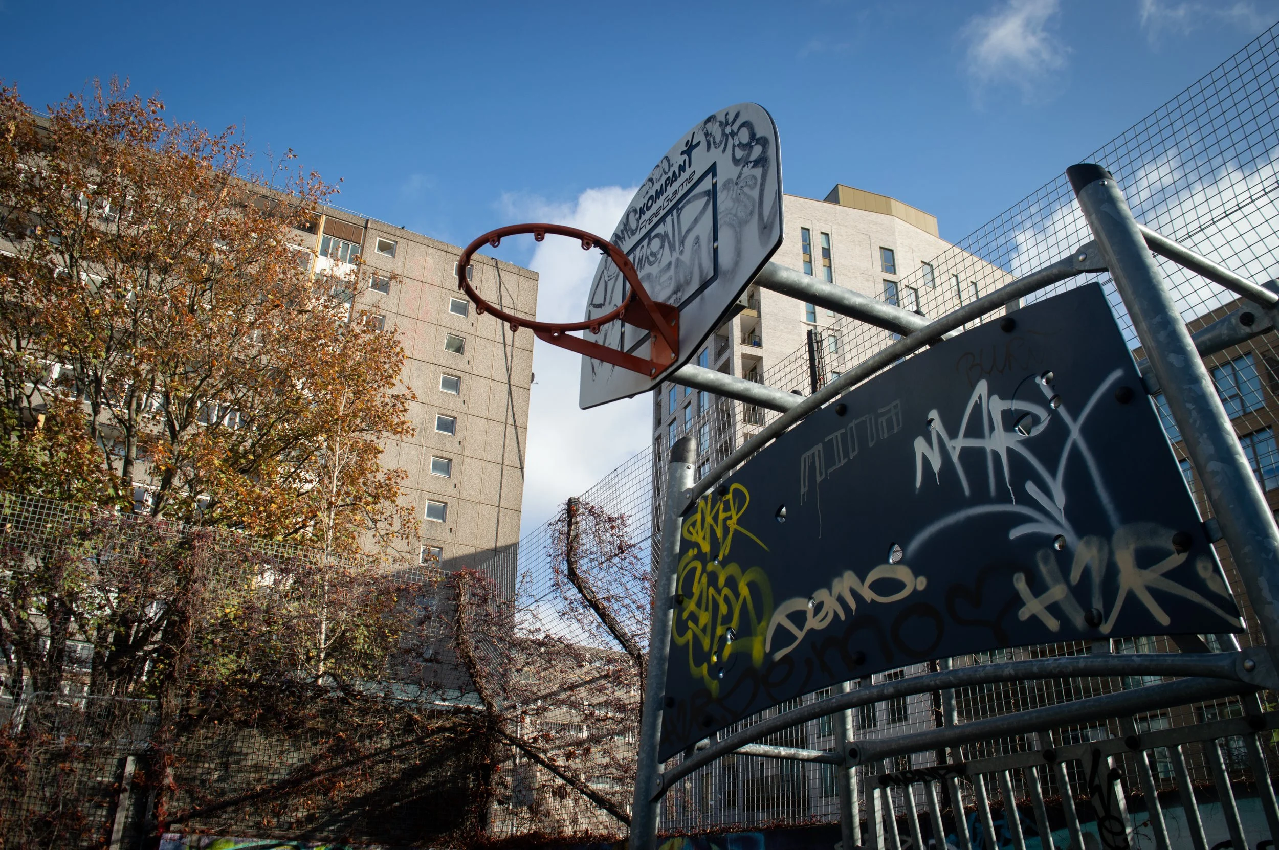 basketball hoop at Aylesbury Estate basketball court with Aylesbury Estate in the background on the lefthand side and on the righthand side is the new estate which was once part of Aylesbury
