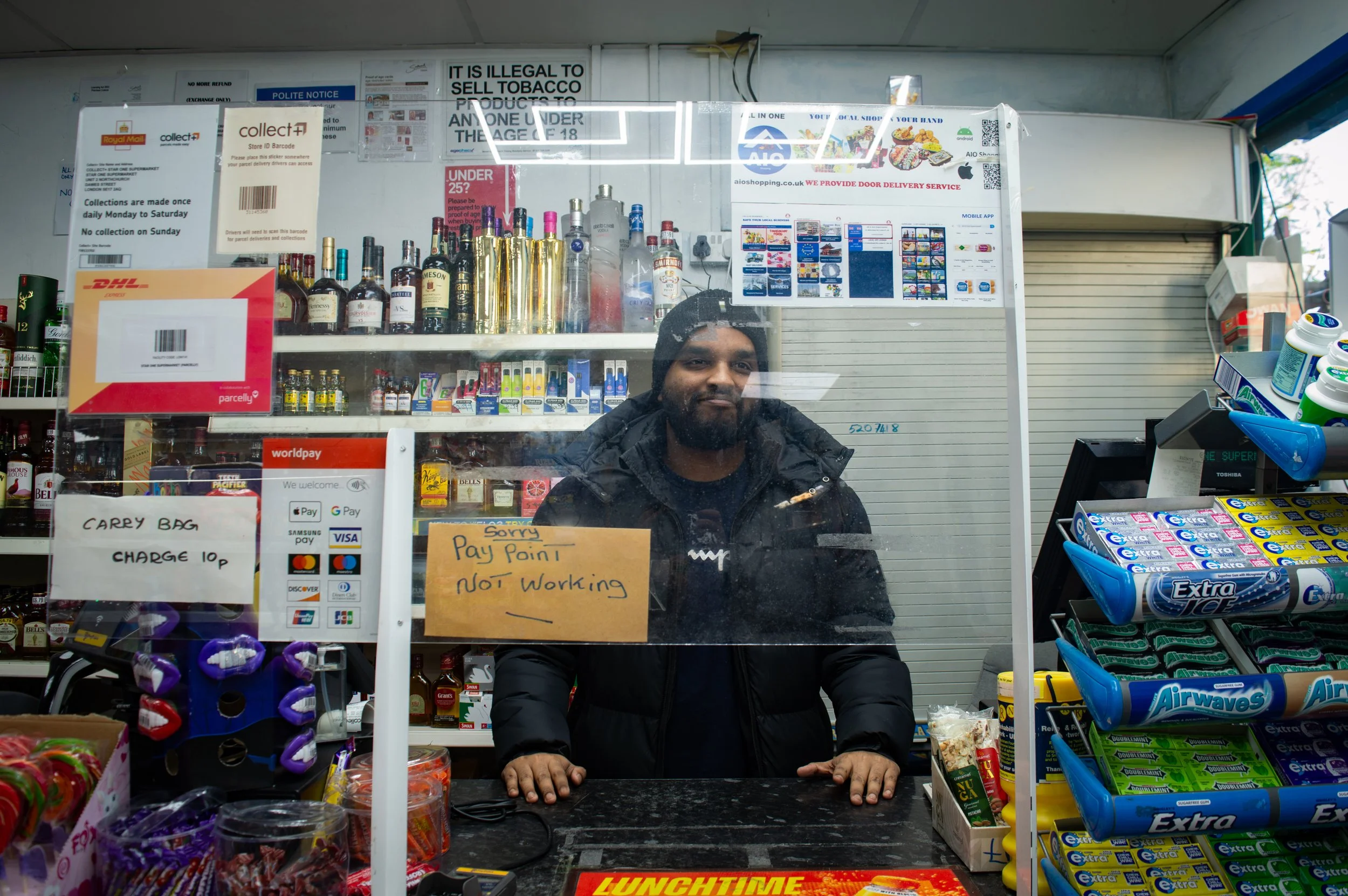 Aylesbury Estate corner shop worker behind the counter 