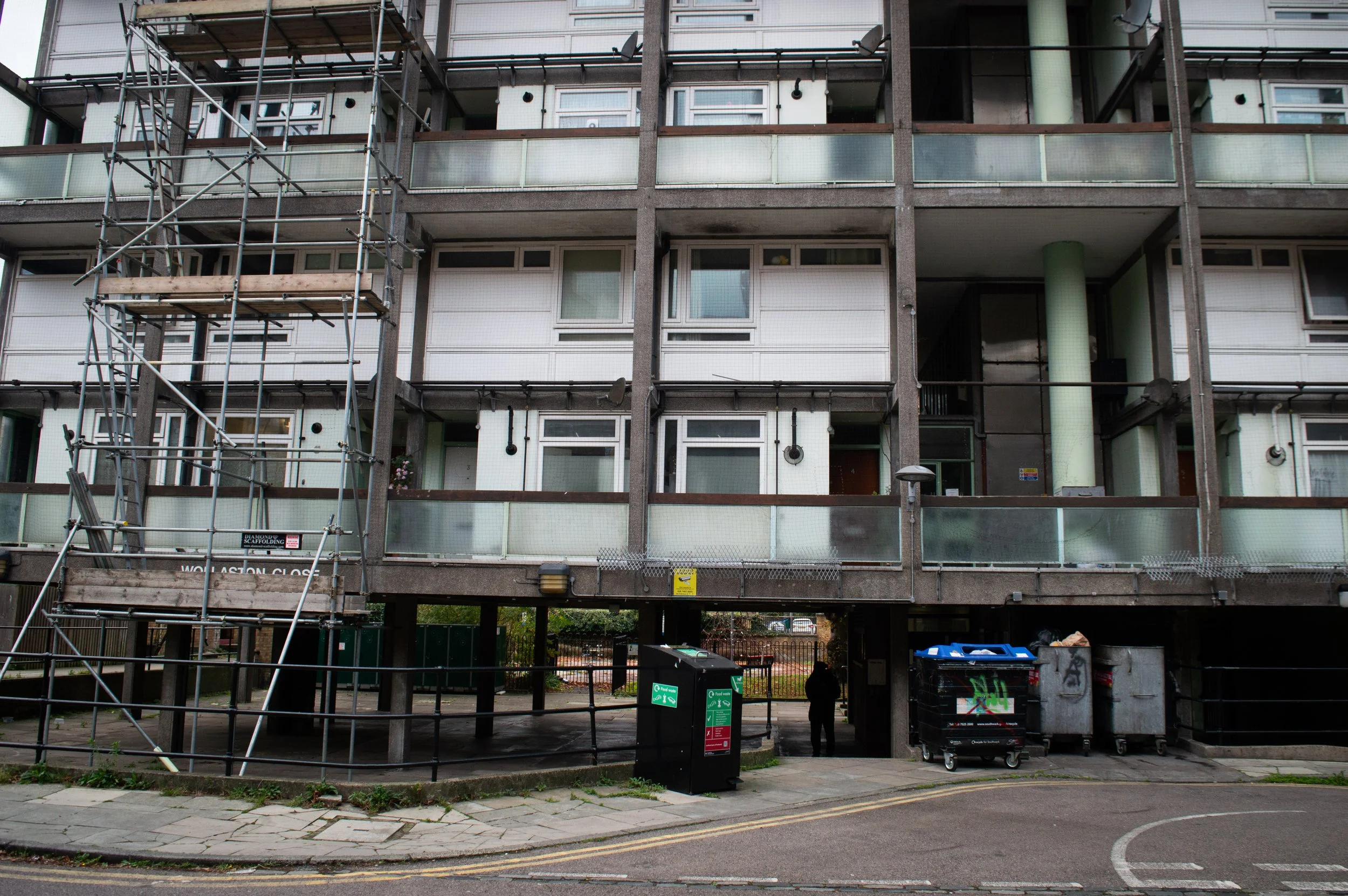 an estate with construction along the right side of it and large bins outside in Southwark