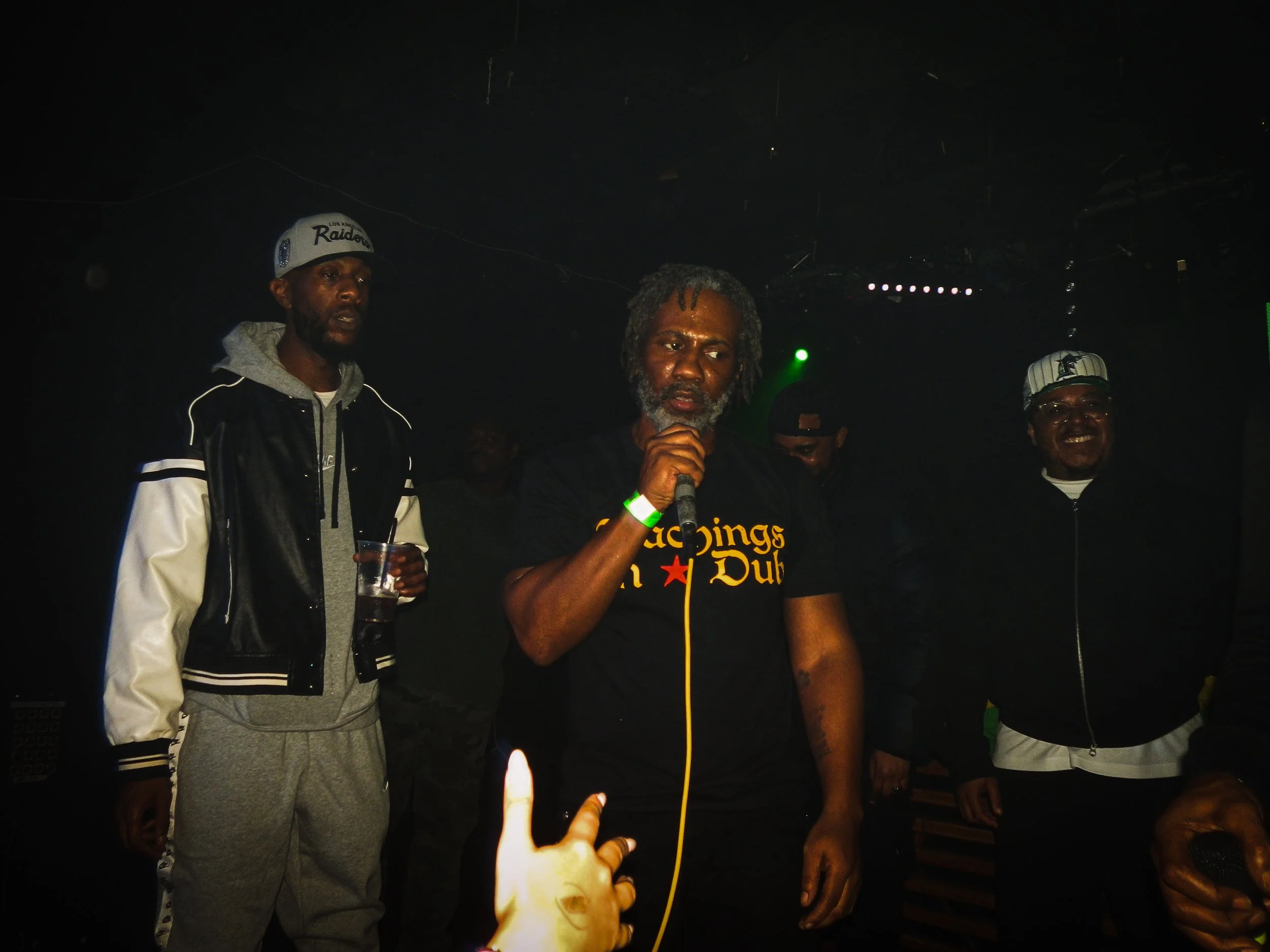 musician footsie mcing with other musicians on stage