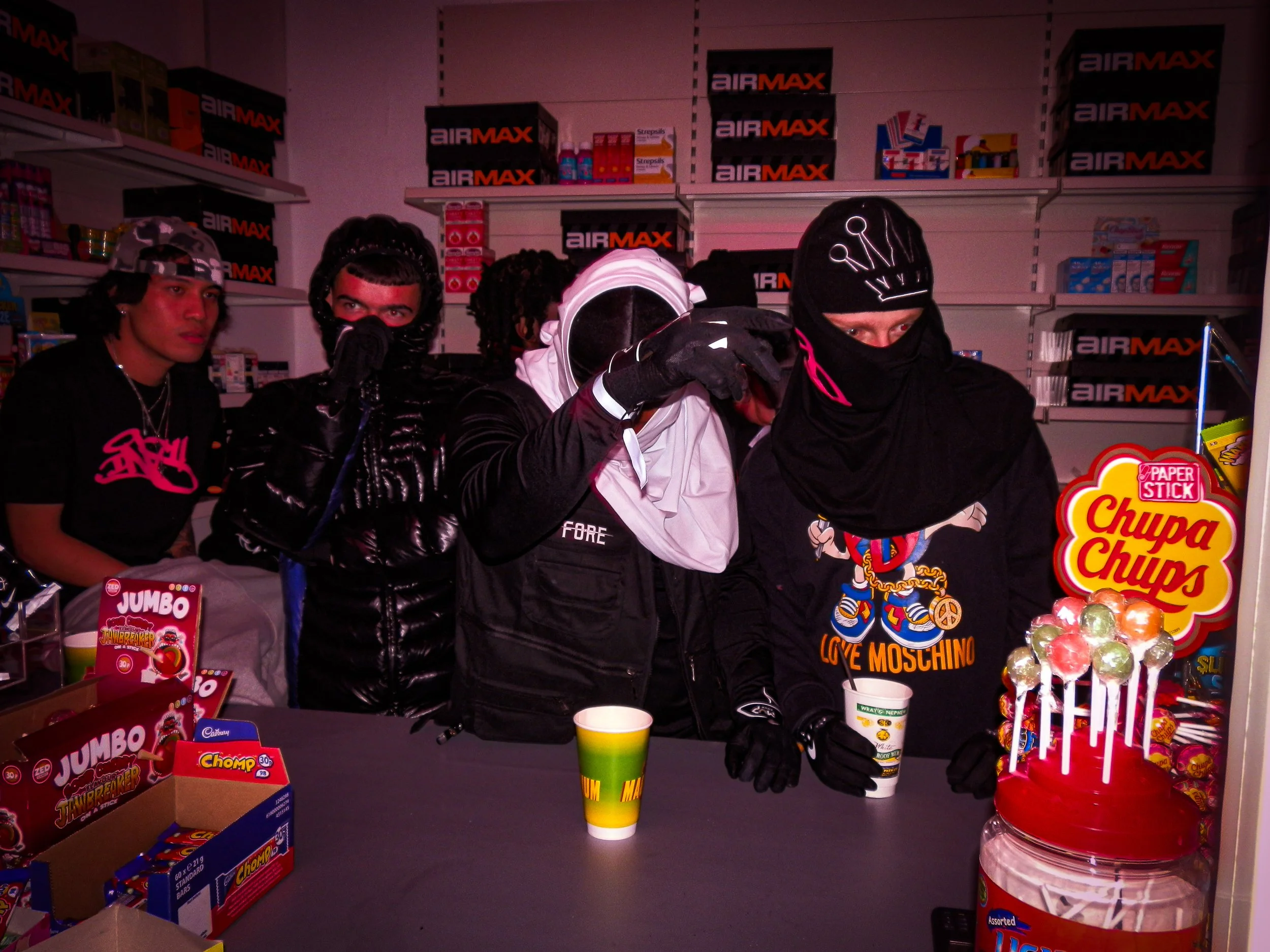 five young men working behind the counter at the Pastdown Vintage x nike pop up shop, majority of them covering faces posing for the camera