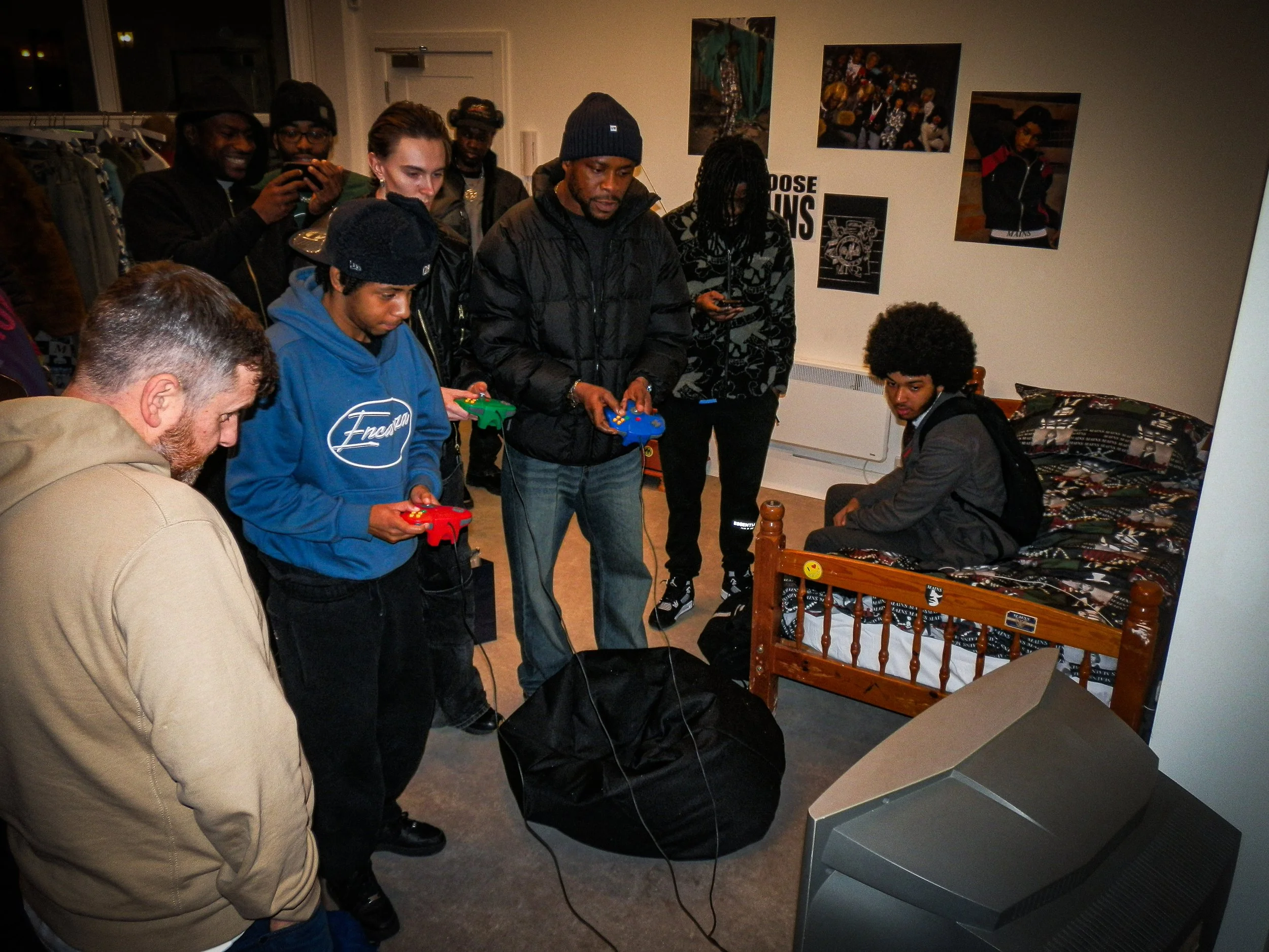 a crowd of people playing retro video games at the mains pop up shop