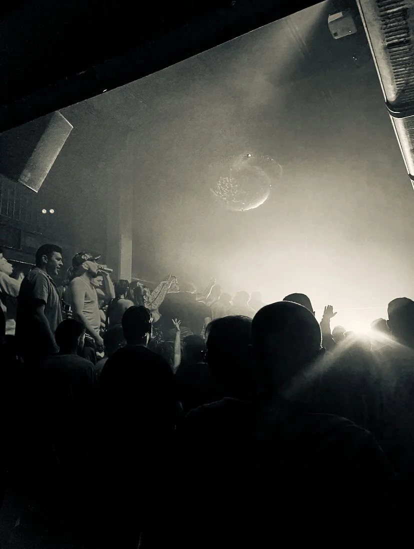 scenic black and white photo of grime rave crowd with a disco ball hanging from the ceiling at jazz cafe Camden, London