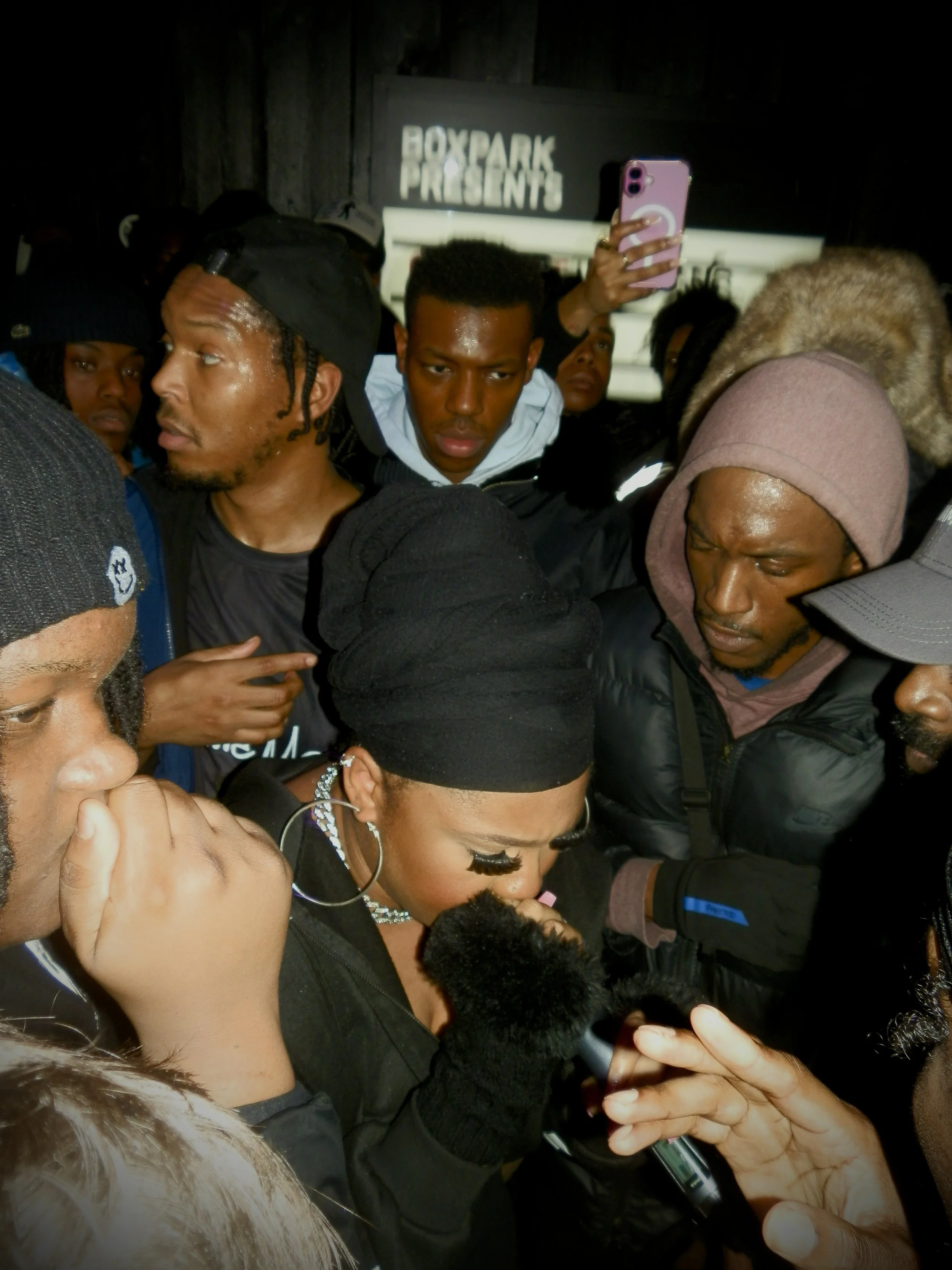 female mc perfoming in the middle of a crowd at JME grime mc fm pop up shop at box park London  