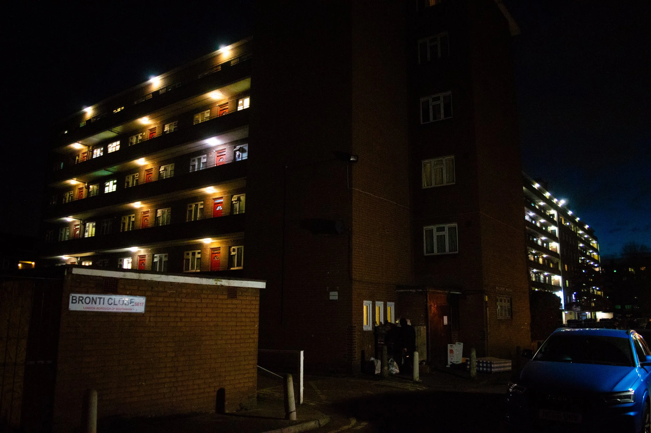 Bronti Close estate at night with bright lights coming from each flat door 