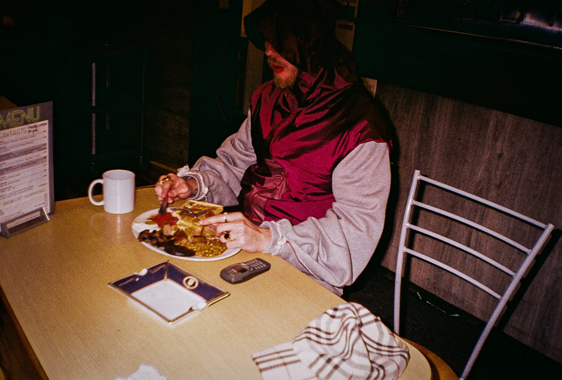 young man modelling Defenda sportswear garments eating a full English breakfast in a cafe