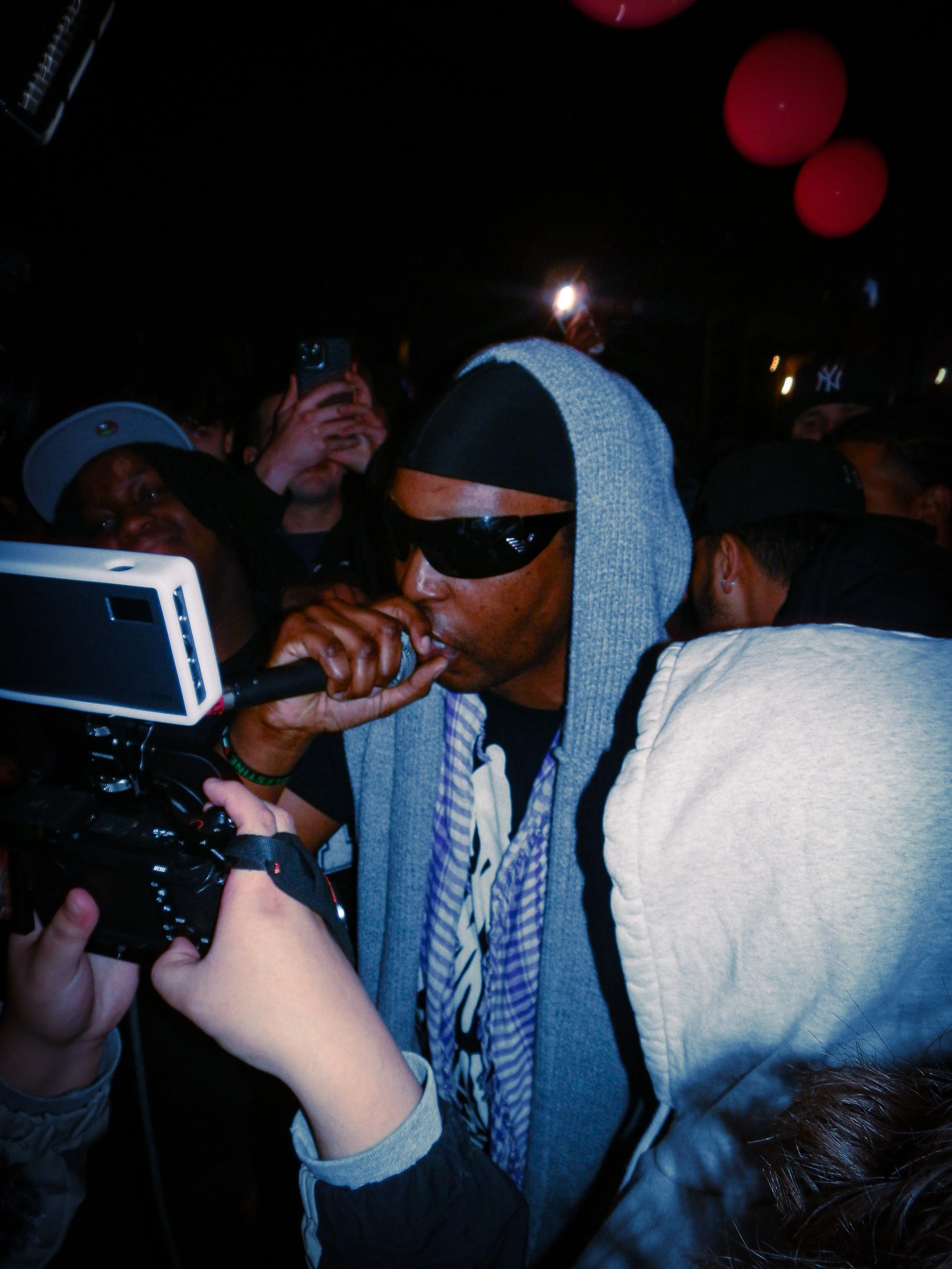 M.I.C performing at travspresents grime rave in the middle of a crowd with camcorders in his face