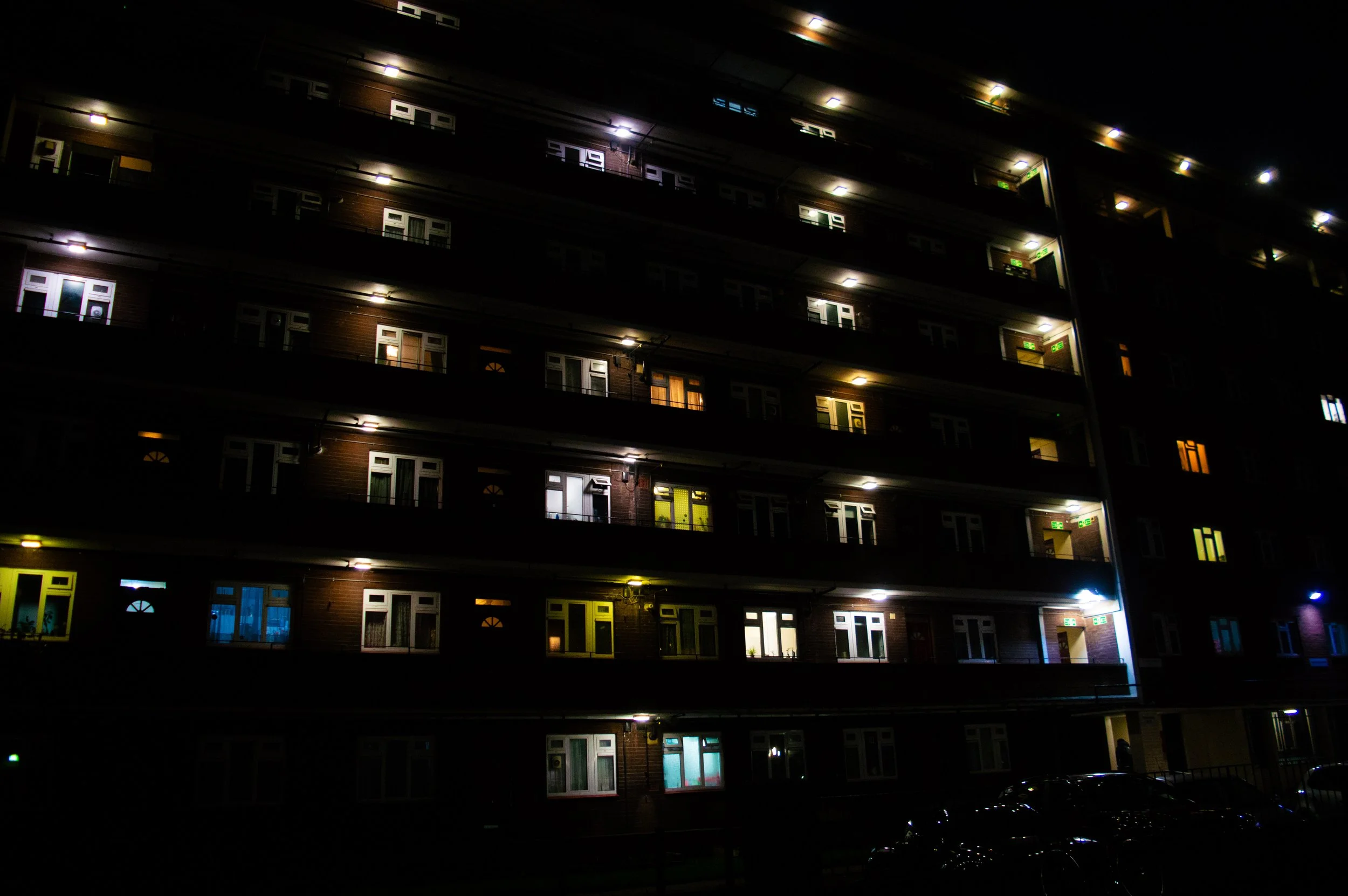 a large council estate block at night with bright colourful lights