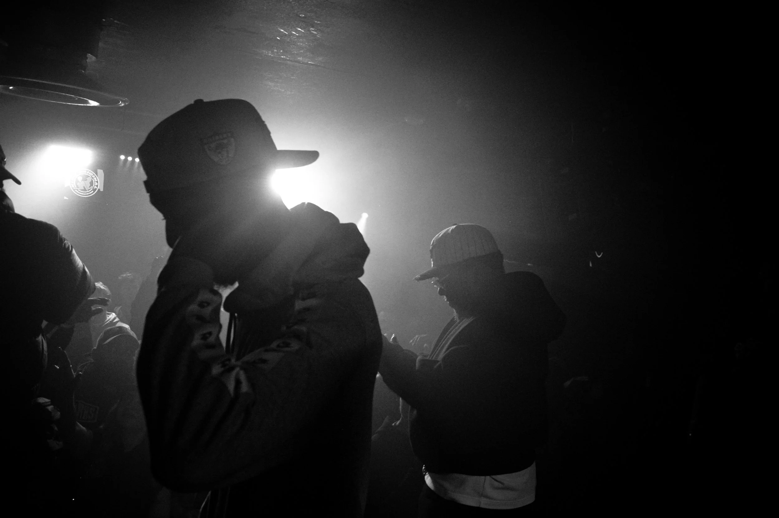 black and white photo of two musicians (Mc's) on stage at a rave