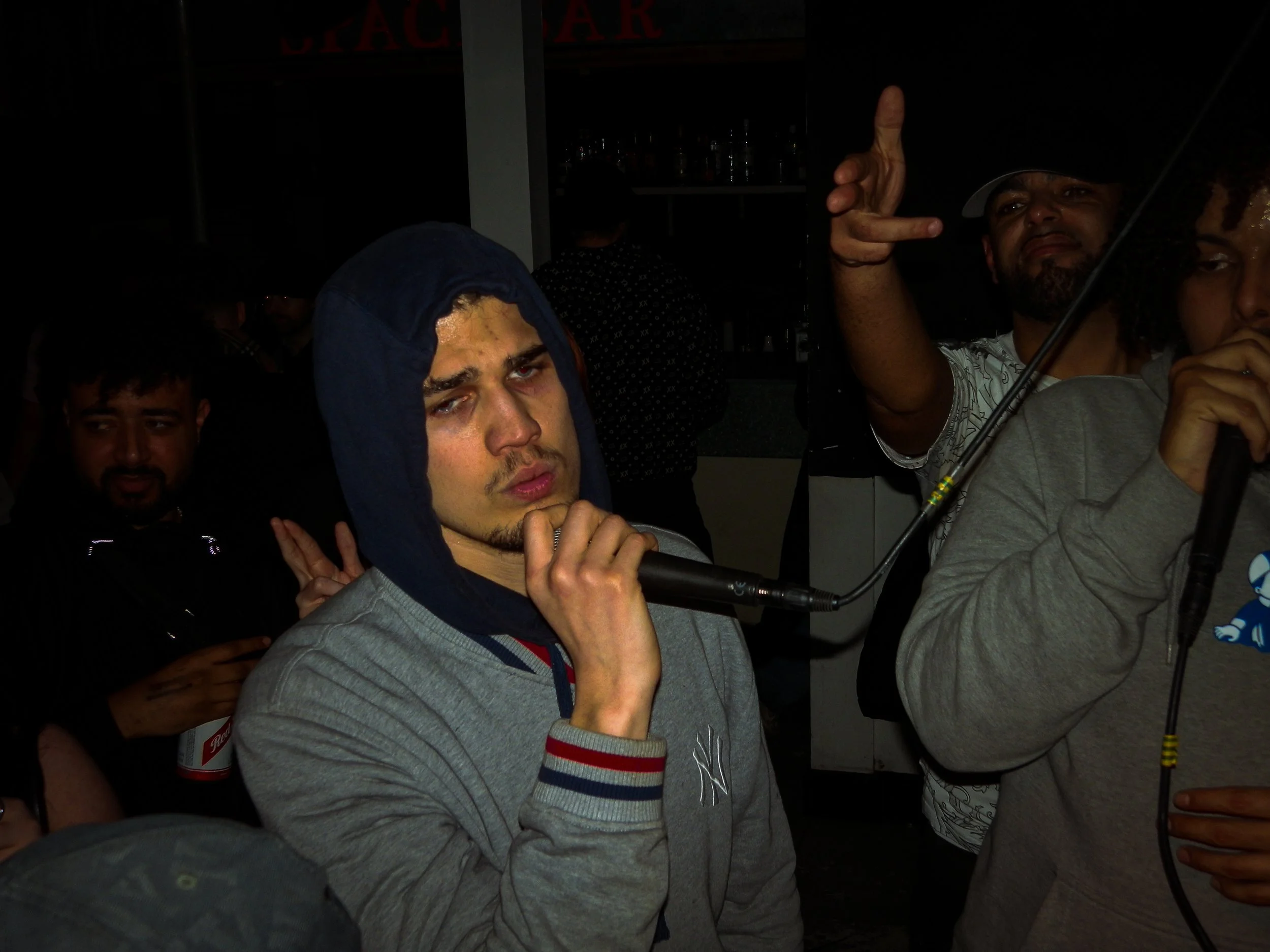 mc performing into mic at wheel up grime rave