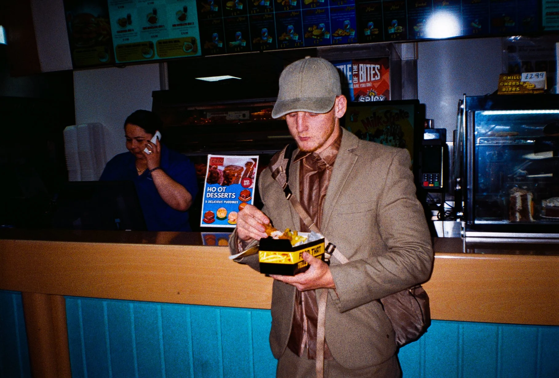 young man eating chicken and chips in chicken shop for Defends sportswear fashion campaign
