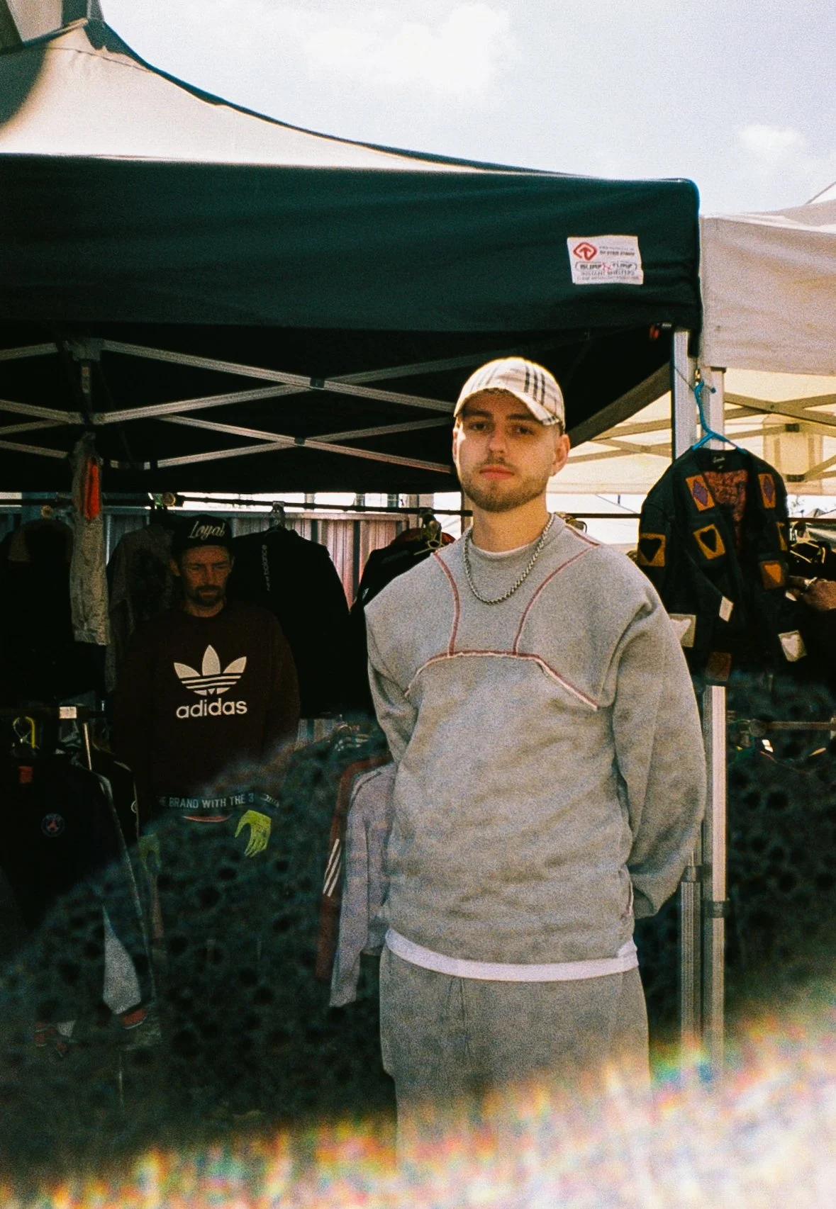 portrait of a young man at a market in Dudley wearing a tracksuit and Burberry baseball cap 